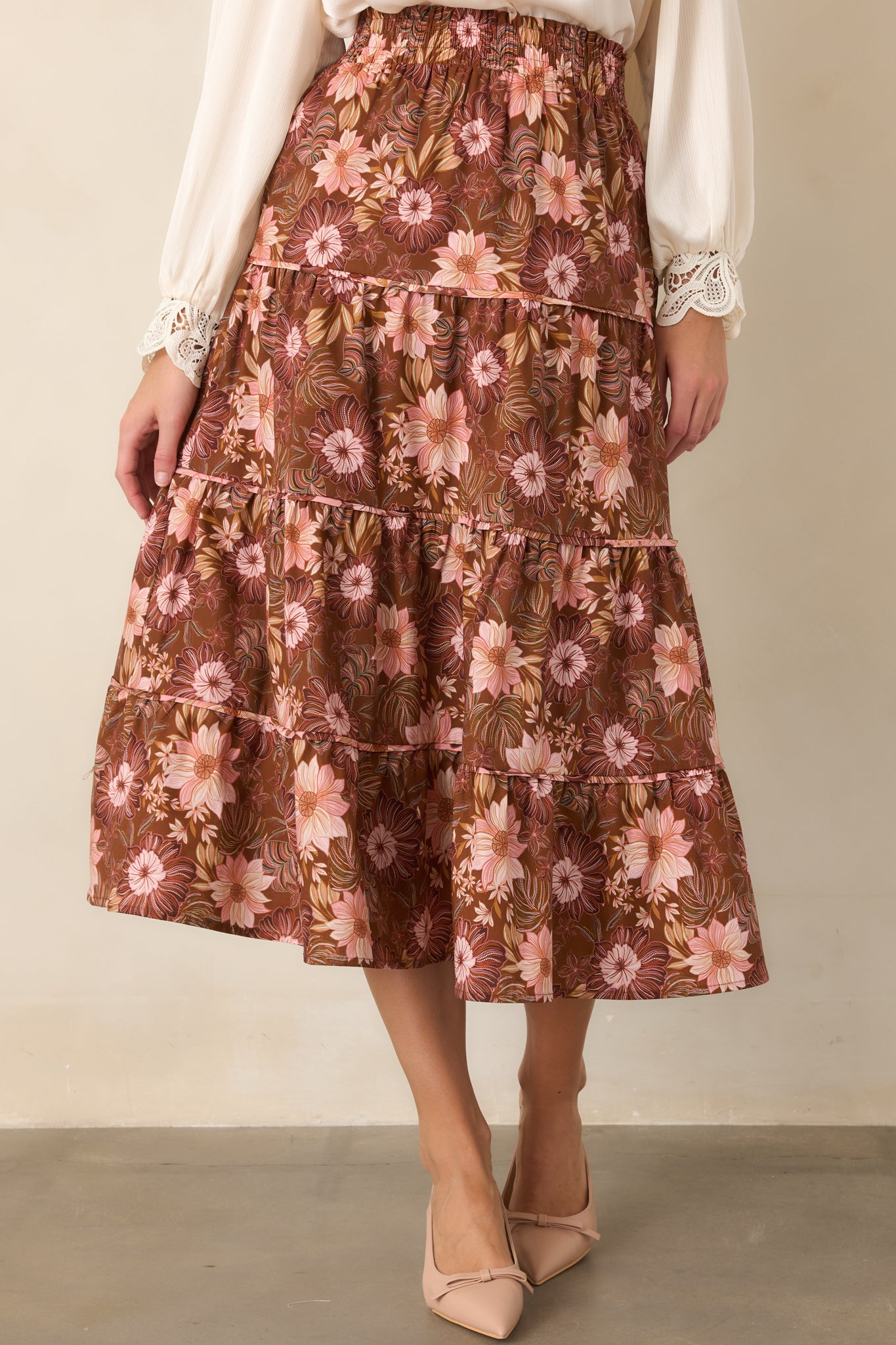 Chocolate brown skirt showcasing its smocked elastic waistband and scattered floral pattern in soft pink, burgundy, and muted green.