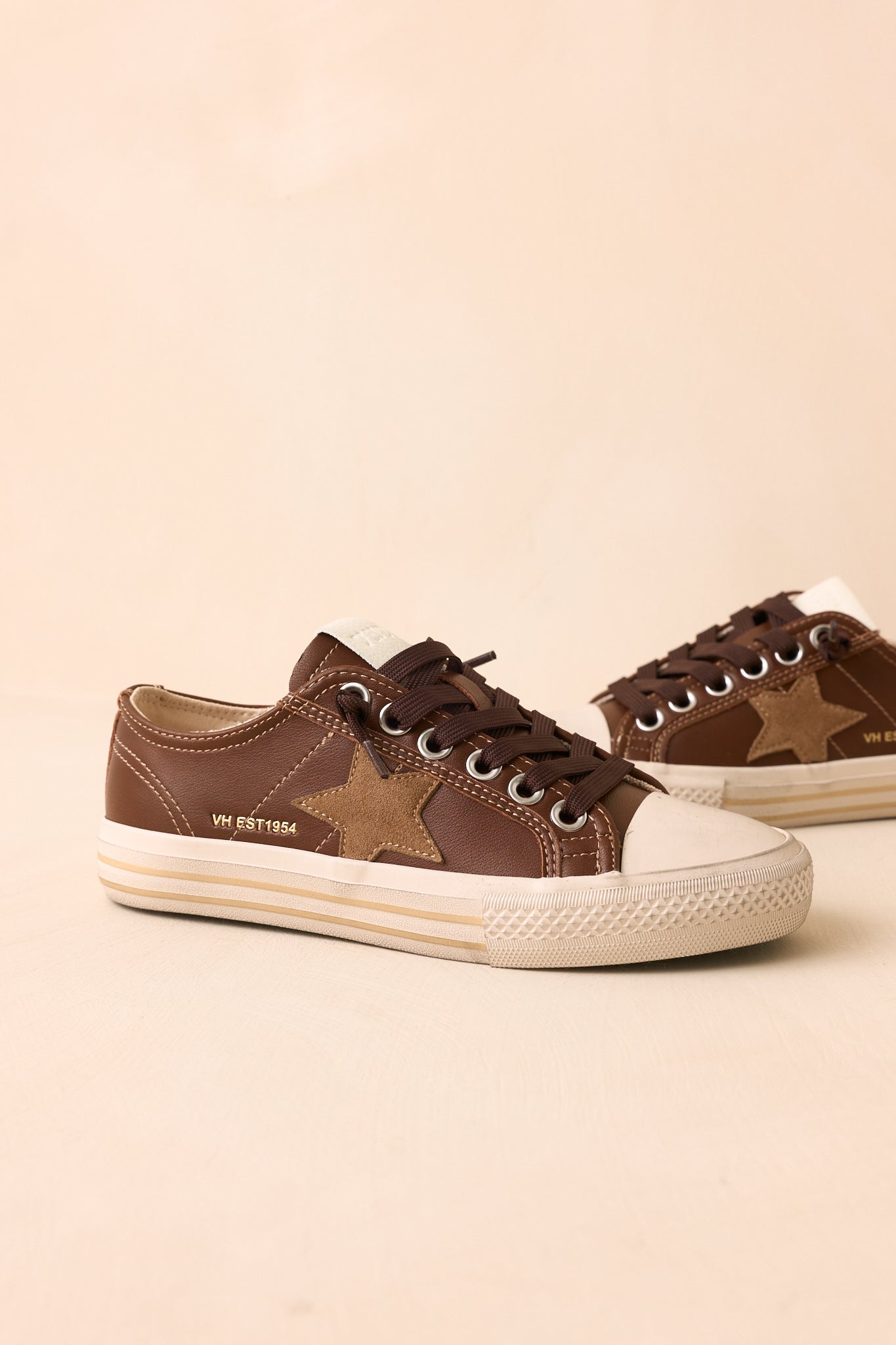 Chocolate brown sneakers showcasing contrast stitching and a textured mix of premium materials.