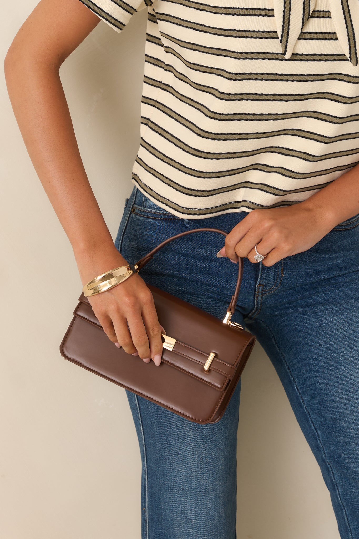 Deep chocolate brown handbag showcasing a structured silhouette, refined top handle, gold-tone hardware, and versatile detachable shoulder strap.