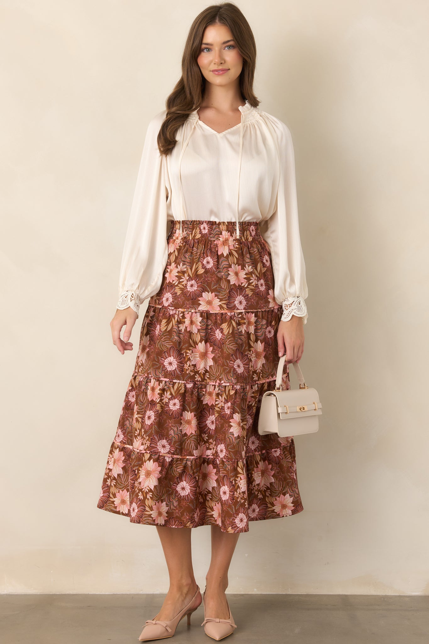 Tiered midi skirt in chocolate brown with delicate pink, burgundy, and muted green florals, finished with a softly flowing hem.