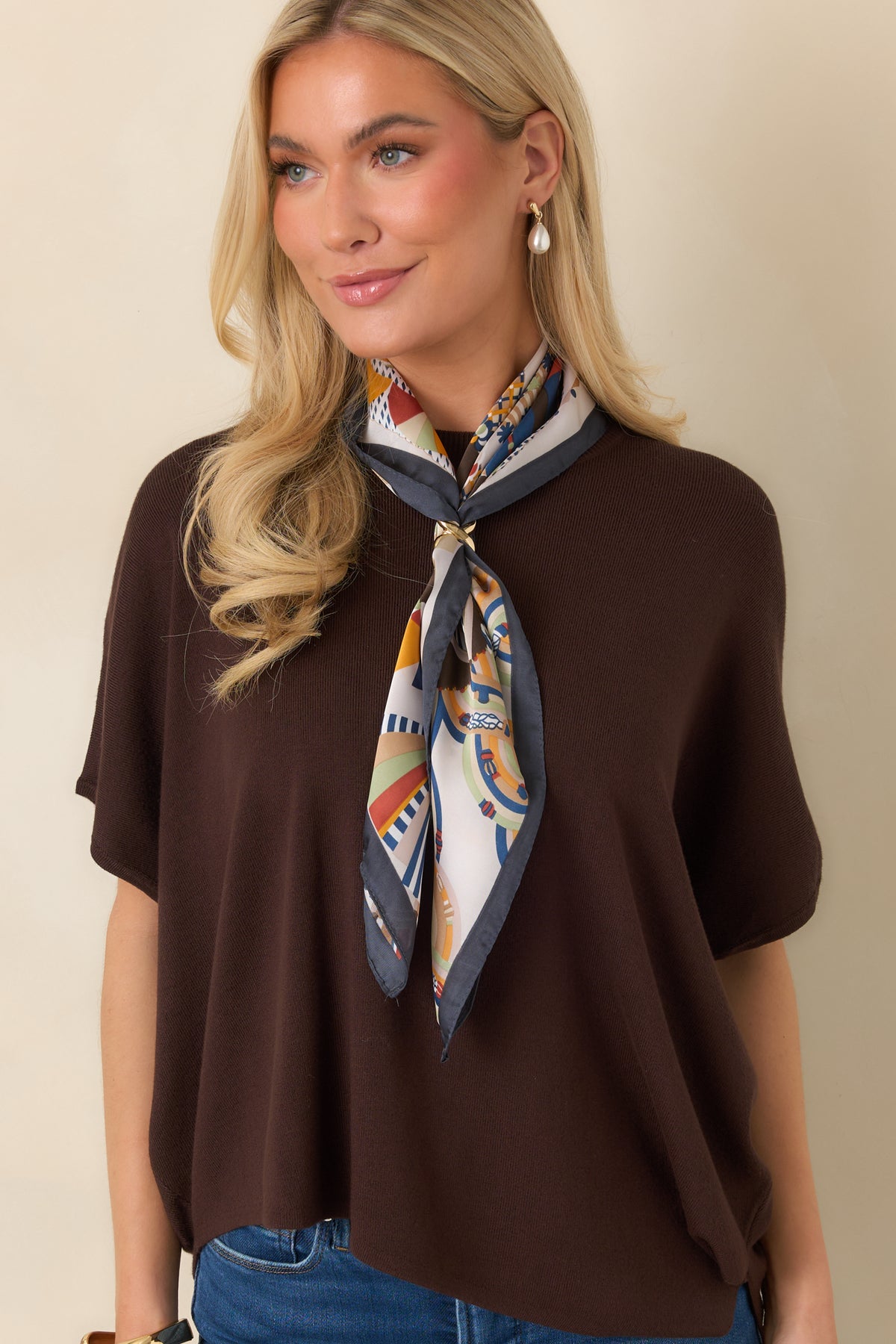 Rich chocolate brown top featuring a loose drape and smooth knit fabric across the front.