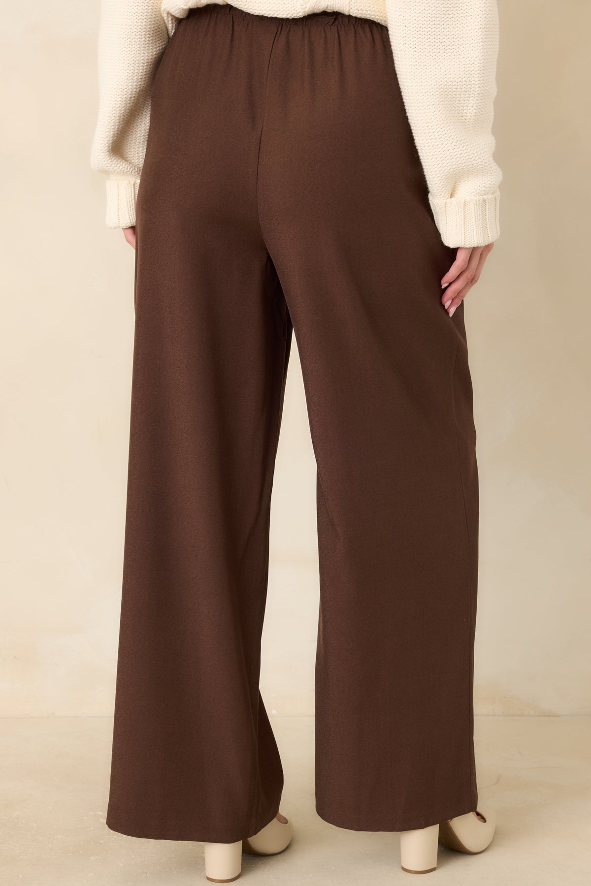 Chocolate brown wide-leg pants with a gathered elastic back waistband and a relaxed full-length fit.