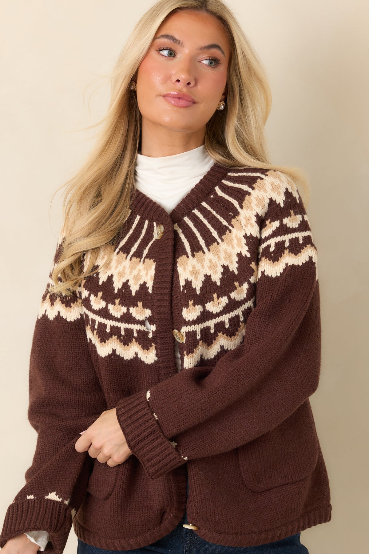 Cream and caramel Fair Isle detailing decorates the upper bodice of the chocolate brown cardigan.