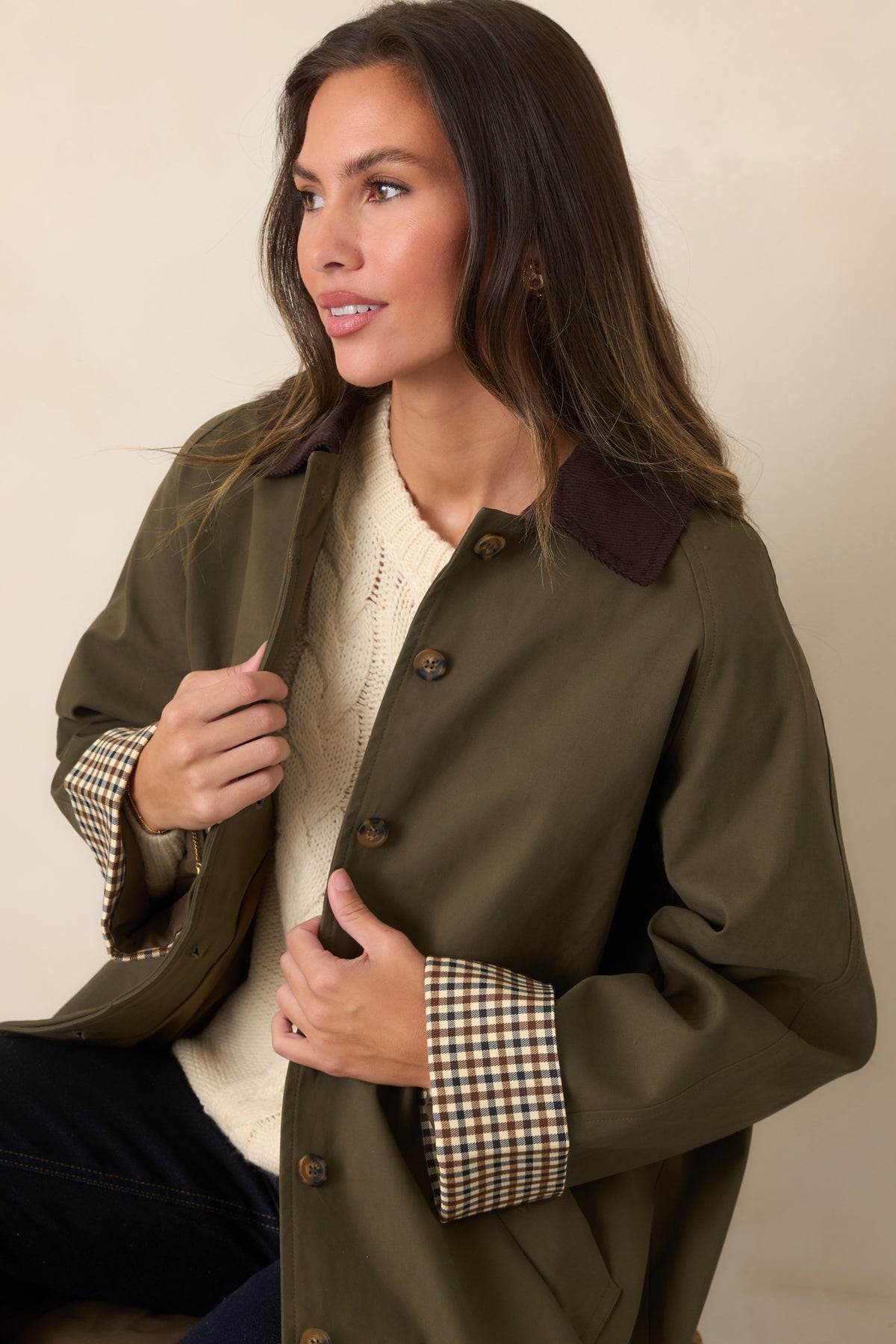 Close-up detail of the chocolate brown corduroy collar and checked contrast cuff on the coat.