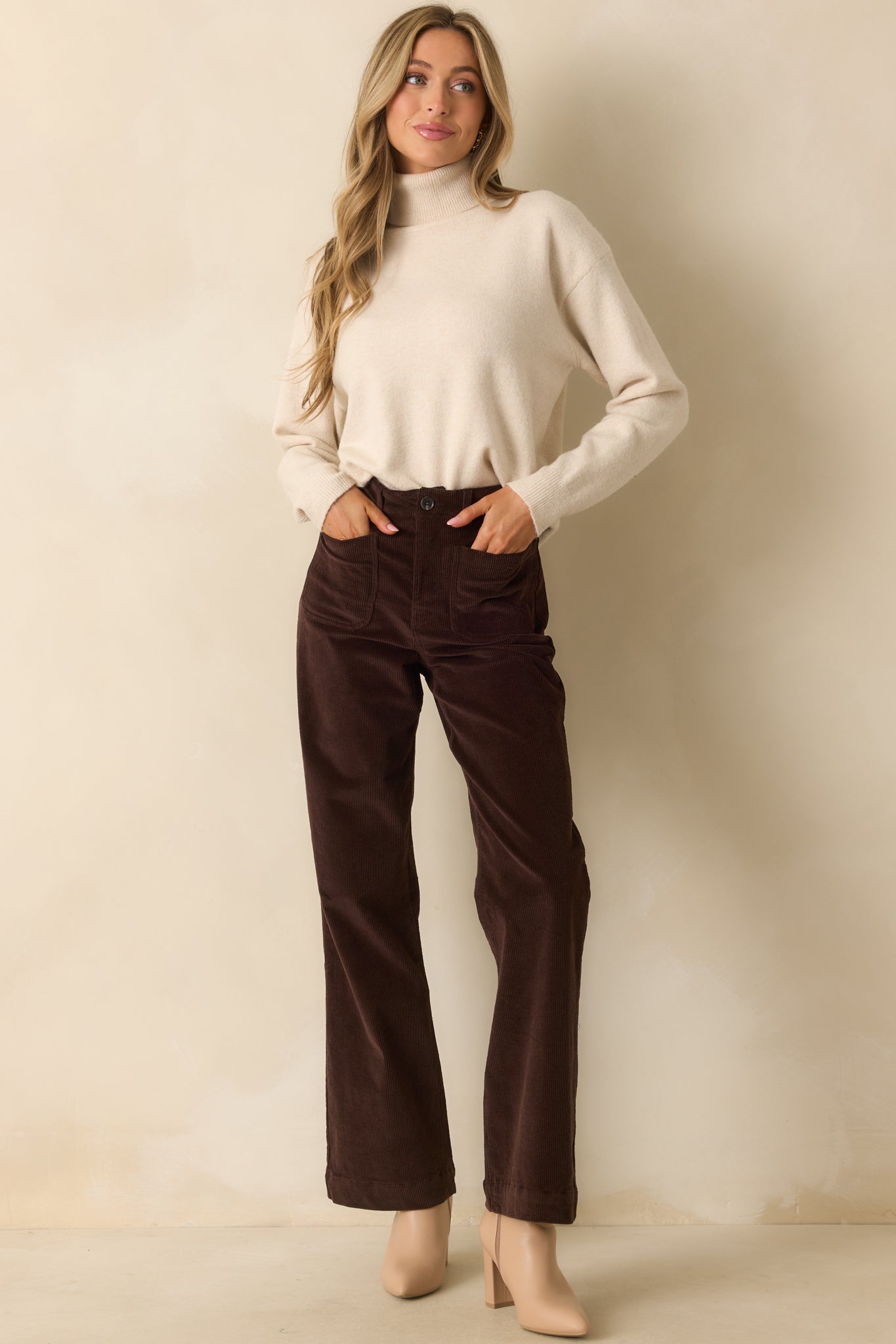 Front view of chocolate brown corduroy pants with functional front patch pockets and belt loops.