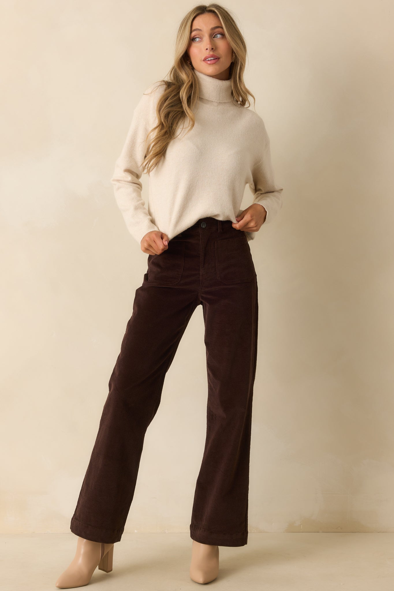 Chocolate brown corduroy pants with a straight-leg silhouette, highlighting the zip fly and single button closure.