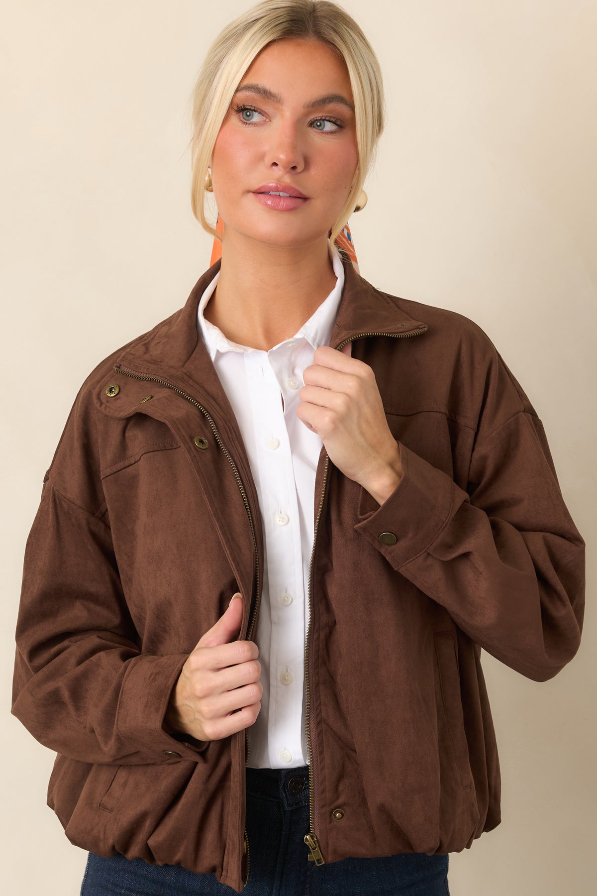 Elasticized hem gathers the chocolate faux suede jacket into a softly rounded bomber shape.