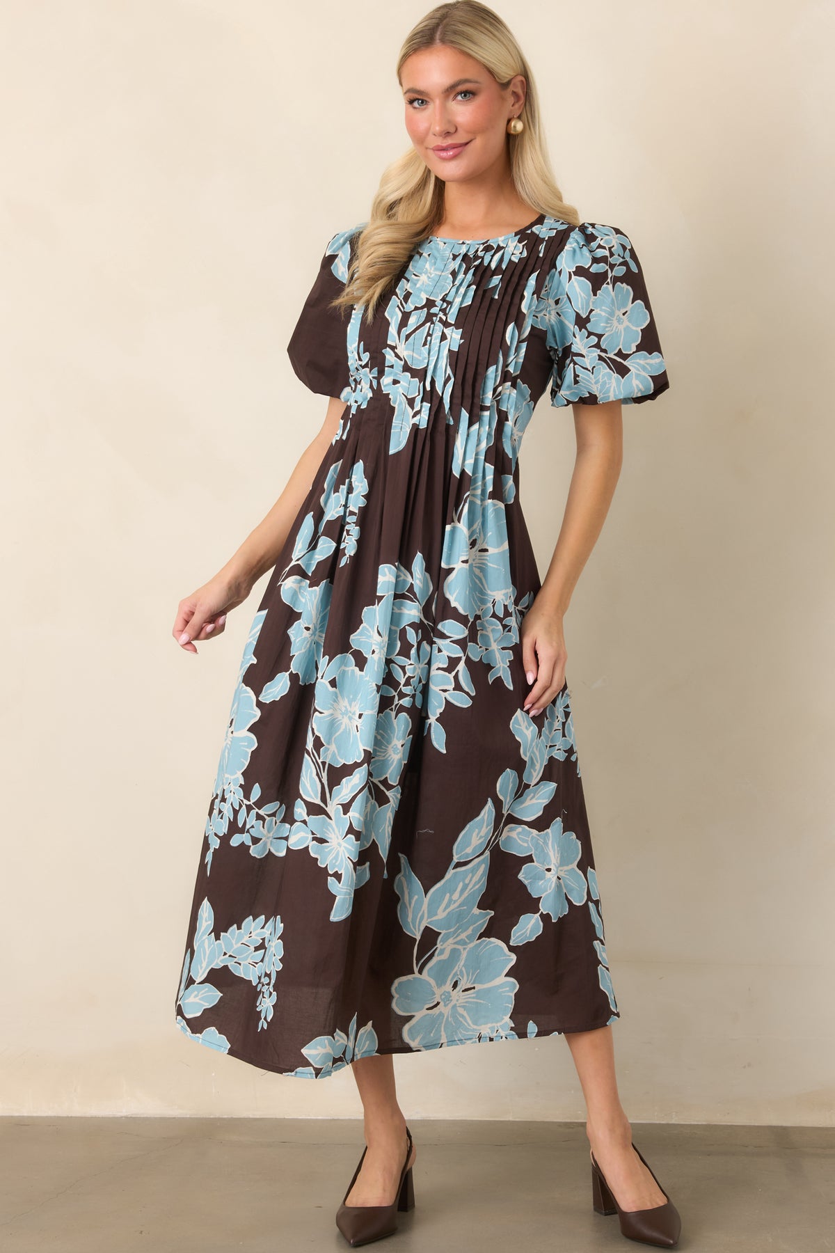 Floral midi dress showcasing a rich chocolate background, romantic puff sleeves, and a graceful defined waist.