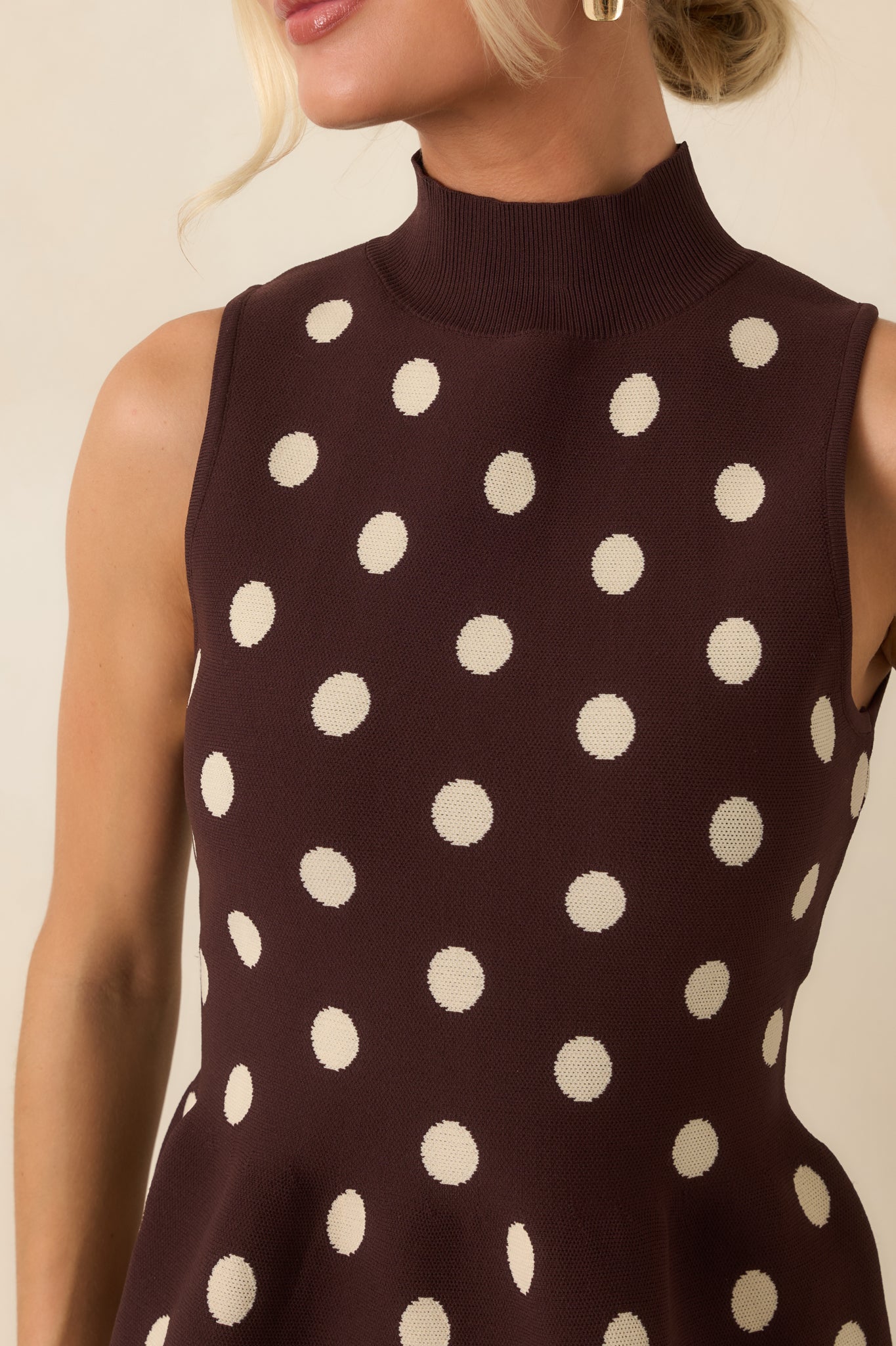 Close-up of the sweater knit top highlighting the ribbed mock neckline, ivory polka dots, and textured fabric.