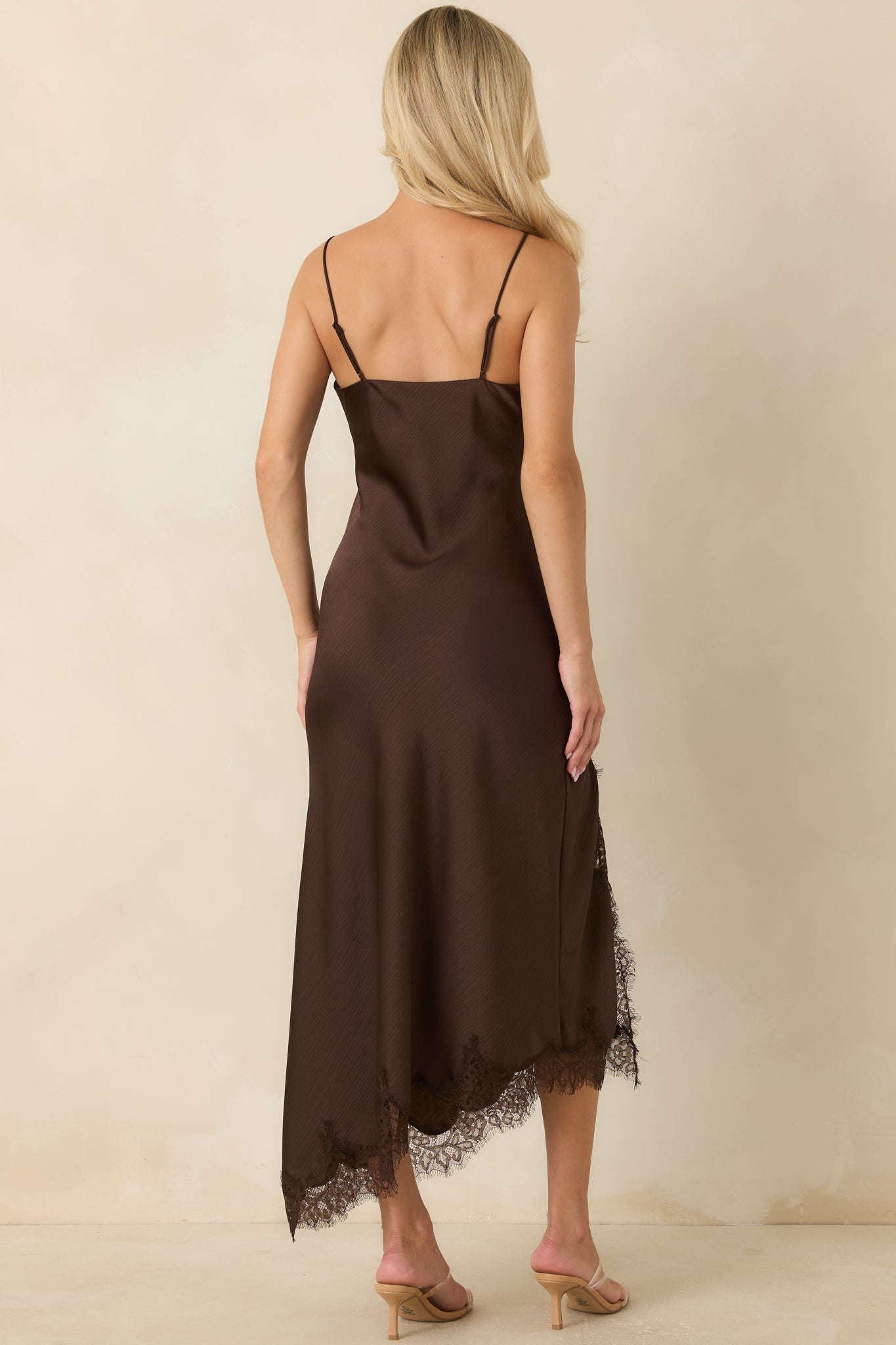 Back of the chocolate satin slip dress featuring adjustable straps and a smooth bias-cut silhouette.