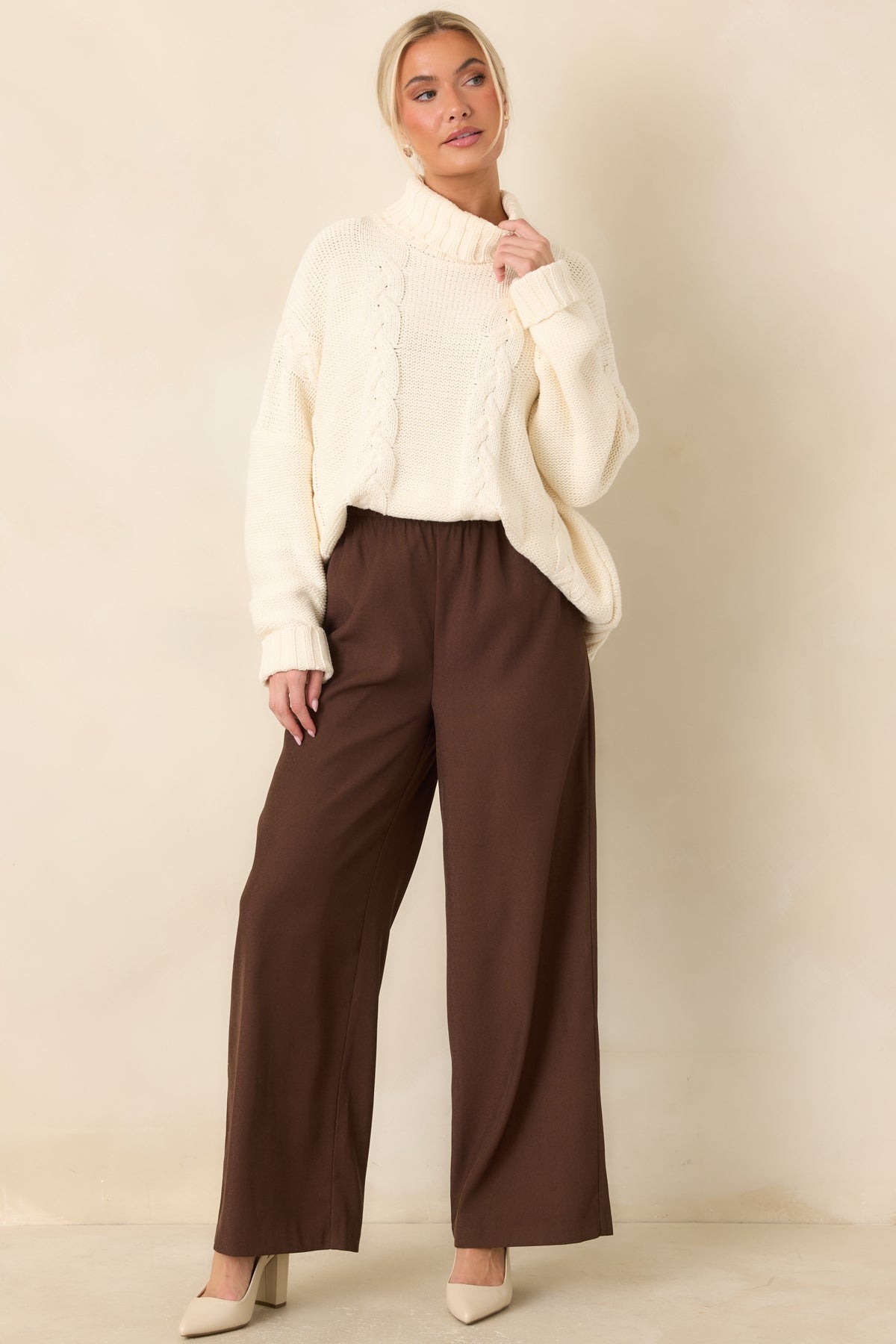 Chunky cable-knit sweater with a wide ribbed turtleneck, dropped shoulders, and a relaxed oversized fit.