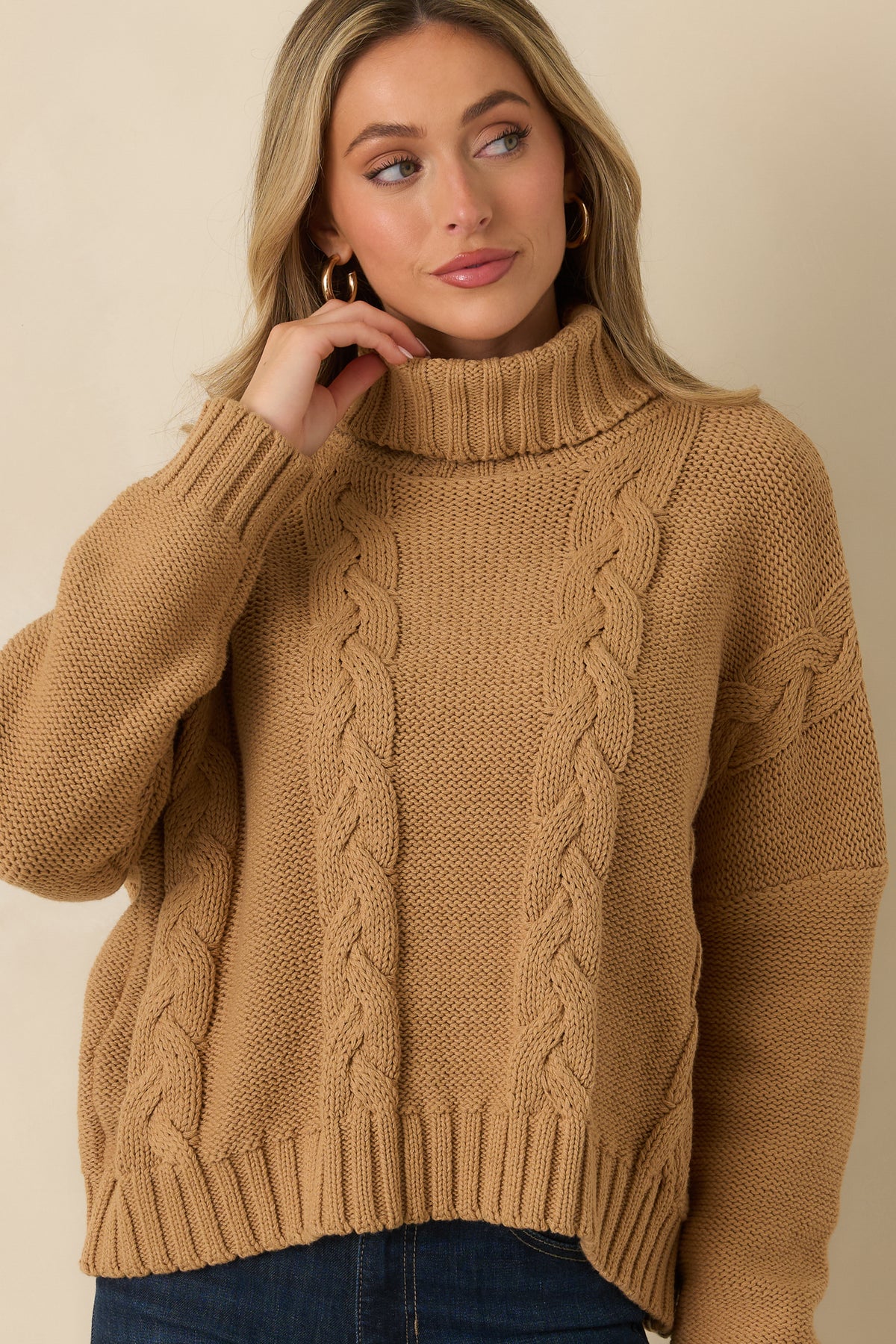 Chunky knit sweater highlighting the wide turtleneck, dimensional cable pattern, and subtly shorter silhouette.