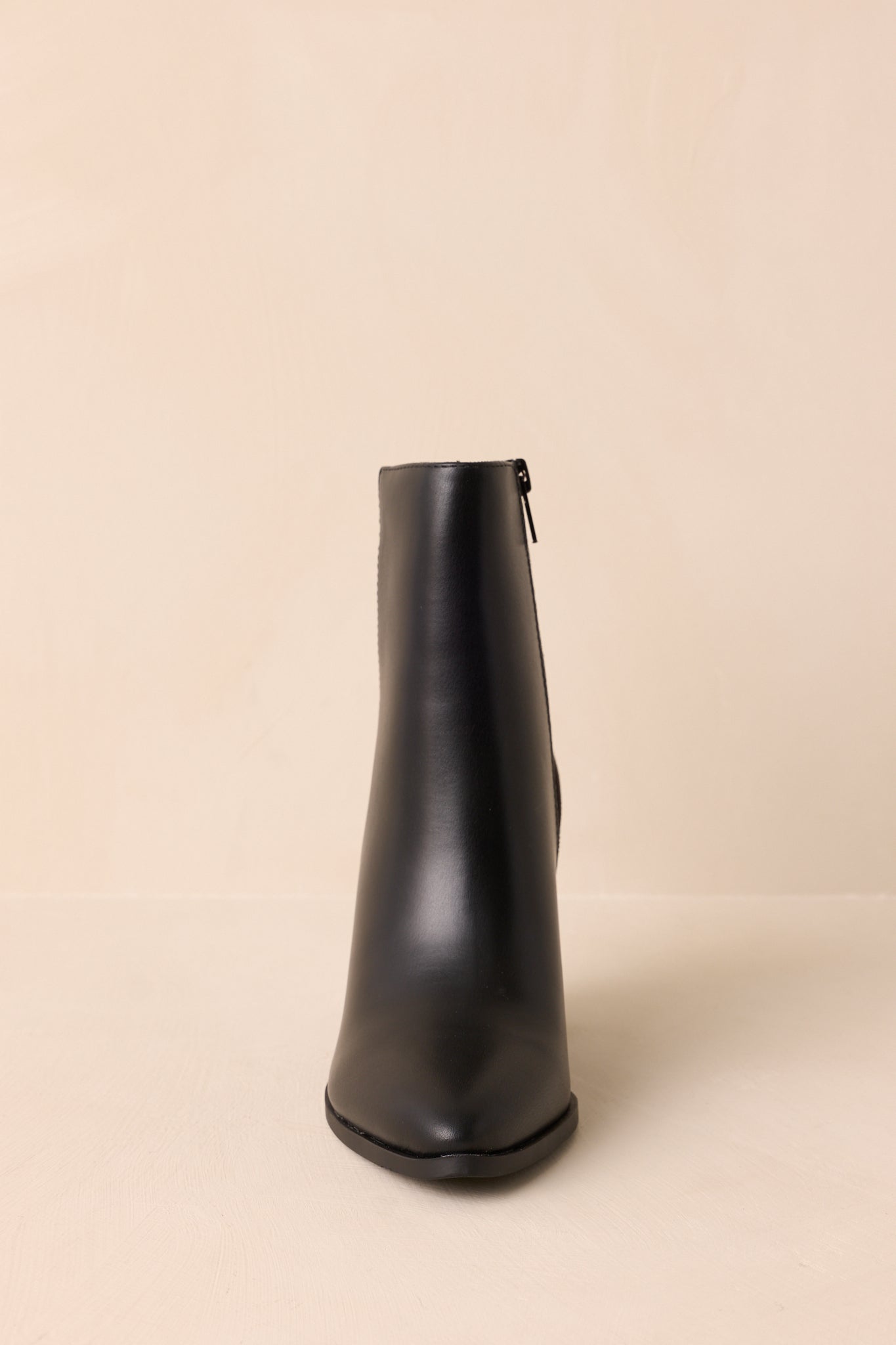 Classic black ankle boots highlighting the pointed toe shape, tonal textures, stacked heel, and versatile everyday construction.