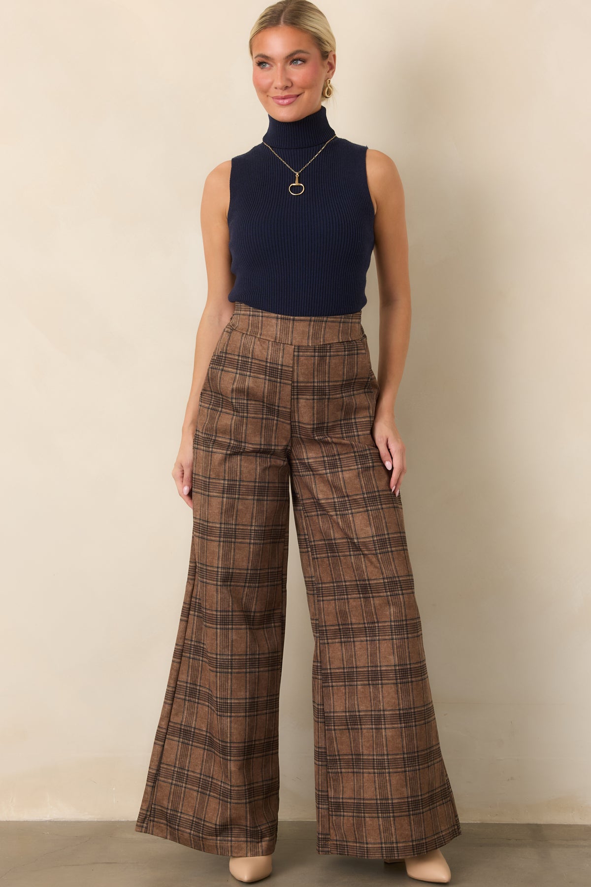 Classic brown plaid trousers designed with a flattering high-rise waist, flowing wide legs, and softly structured fabric.