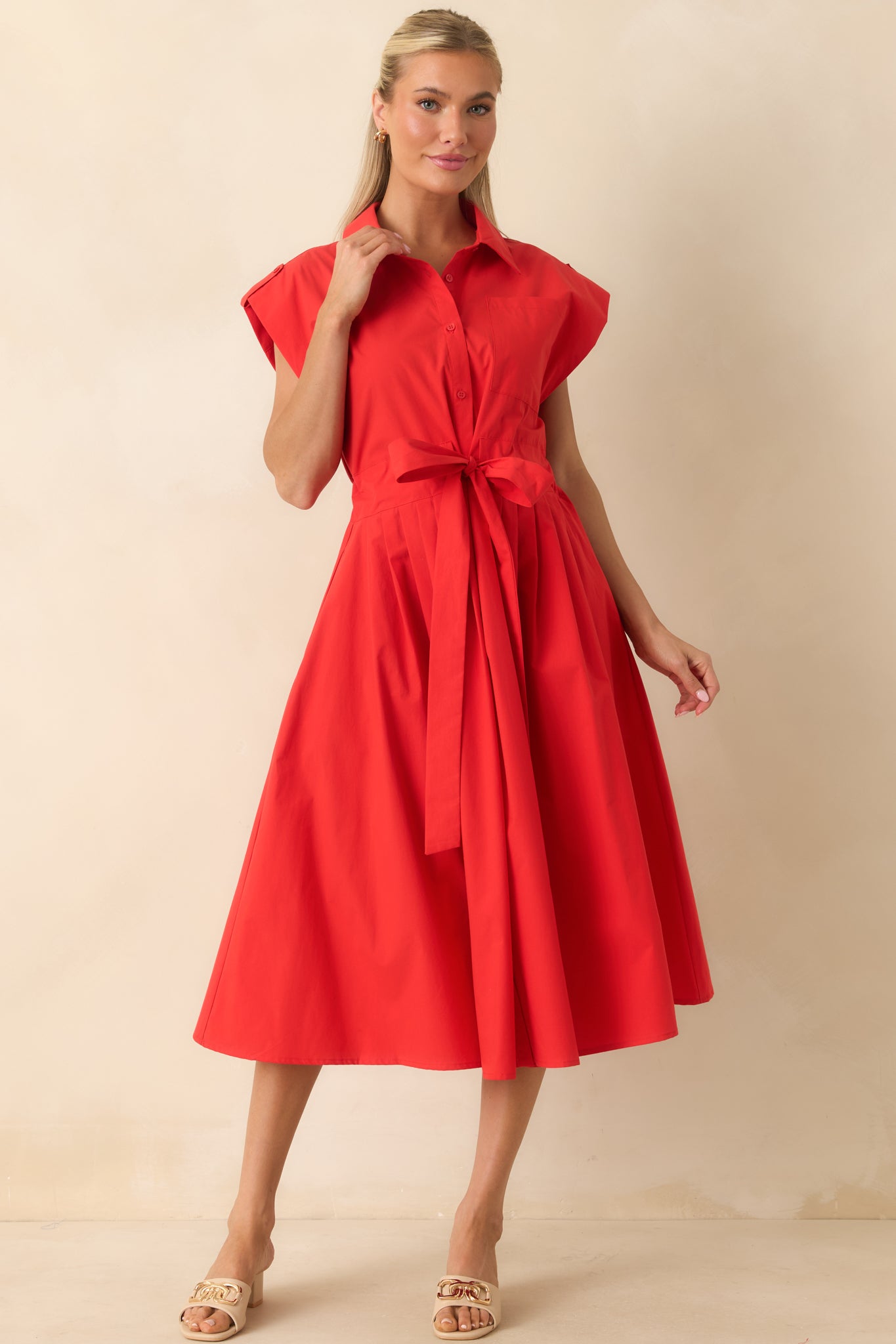 Classic button-front midi dress featuring a fitted waist, cap sleeves, and a voluminous pleated skirt.