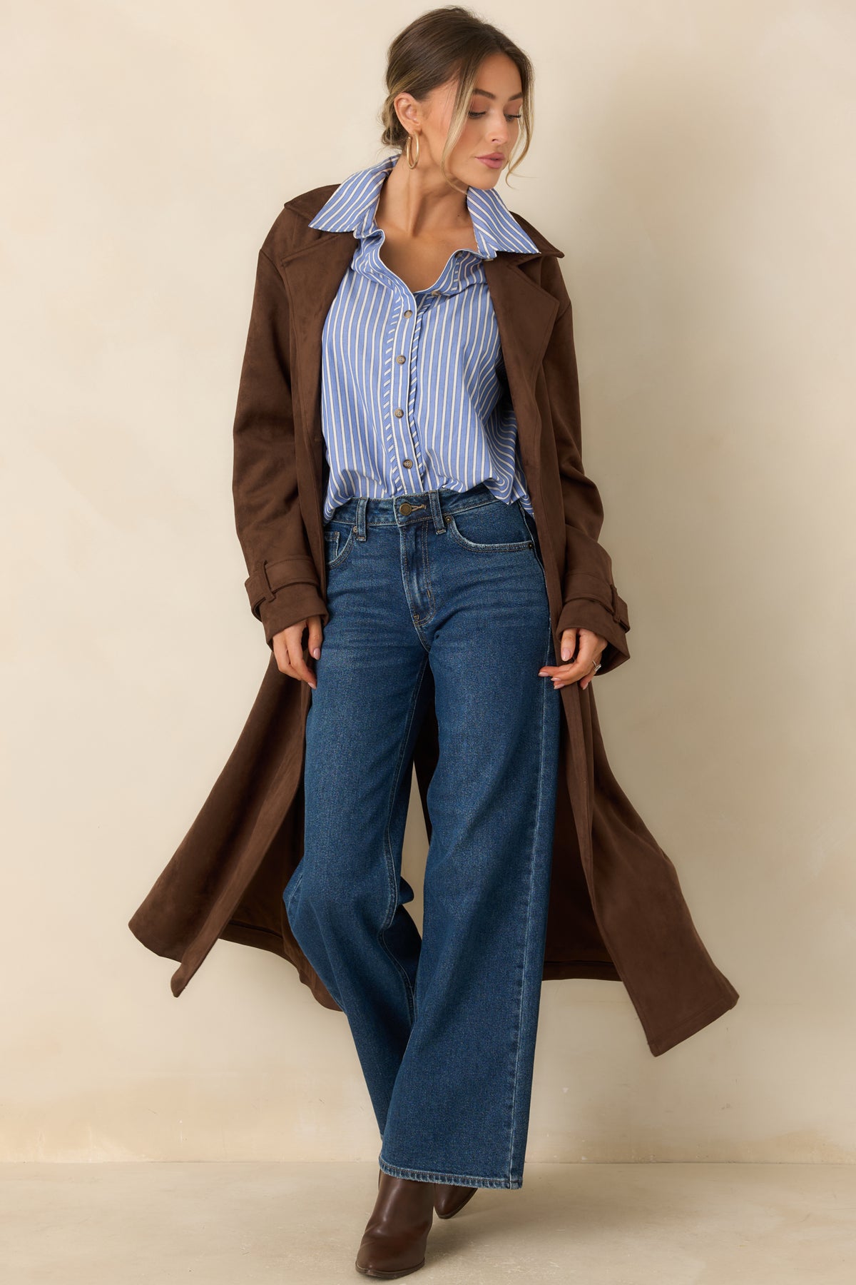 Classic coat combines a double-breasted closure with a matching tie belt, long sleeves, and practical side pockets.