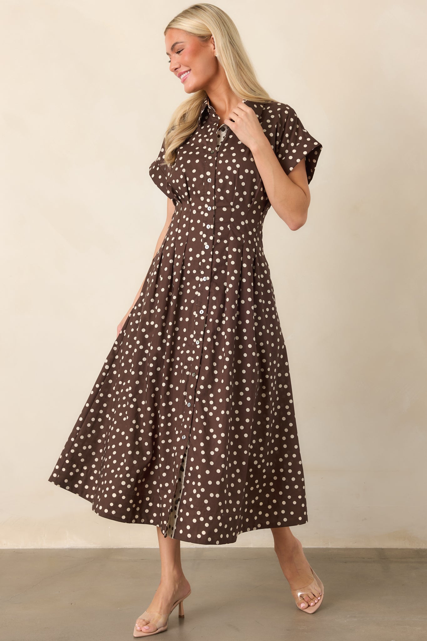 Classic fit-and-flare cotton dress designed with short sleeves, a button-front bodice, shaped waist seams, and a full midi skirt with functional pockets.