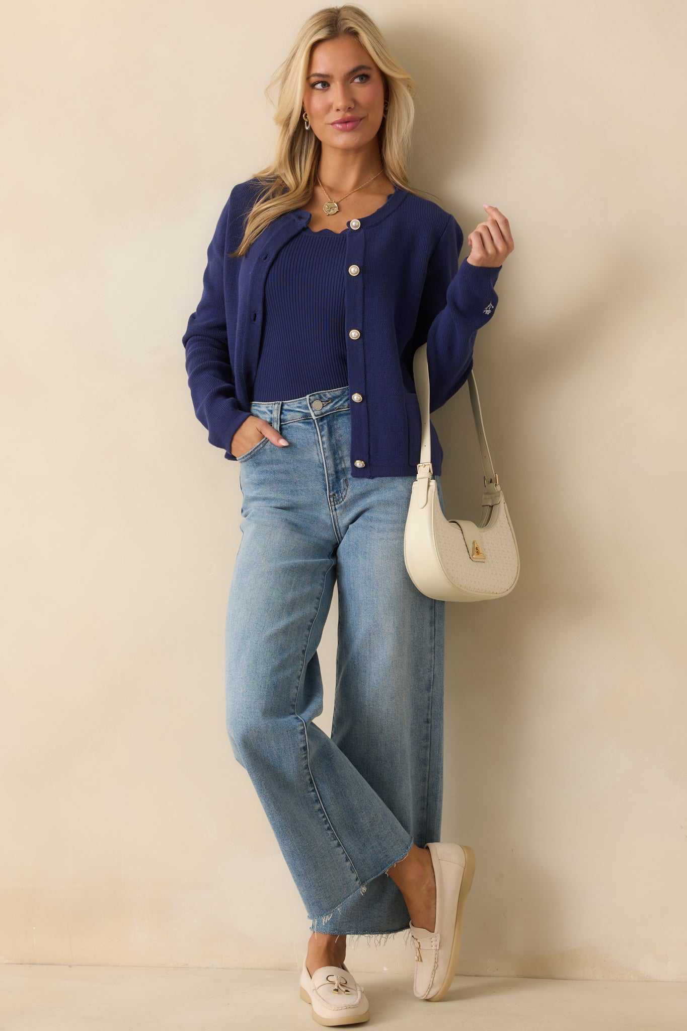Classic cotton knit cardigan featuring a button-front design, crew neckline, and front patch pockets for a timeless look.