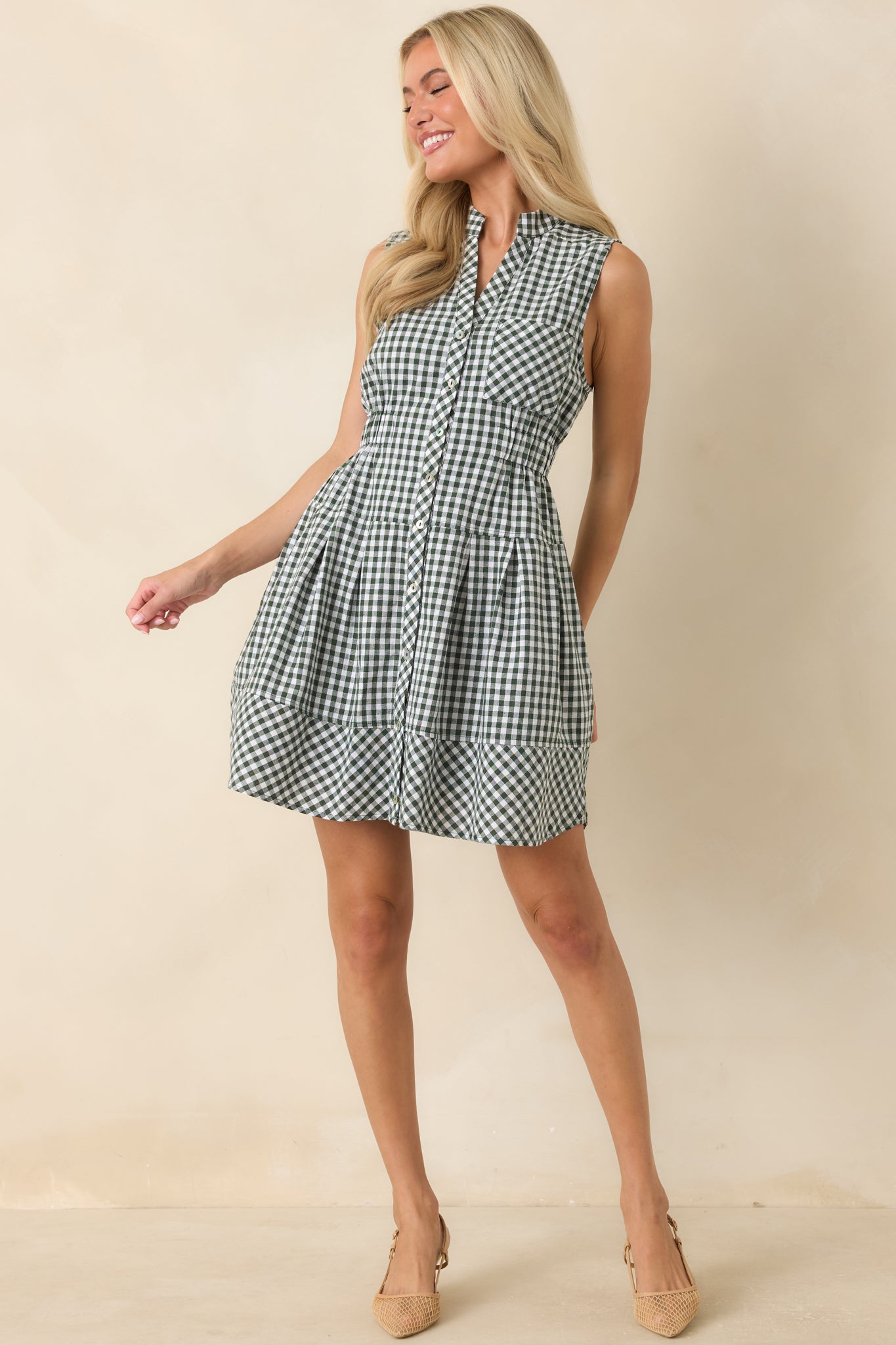 Classic gingham mini dress featuring a collared neckline, button-front placket, elastic waistband, chest pocket, and relaxed silhouette.