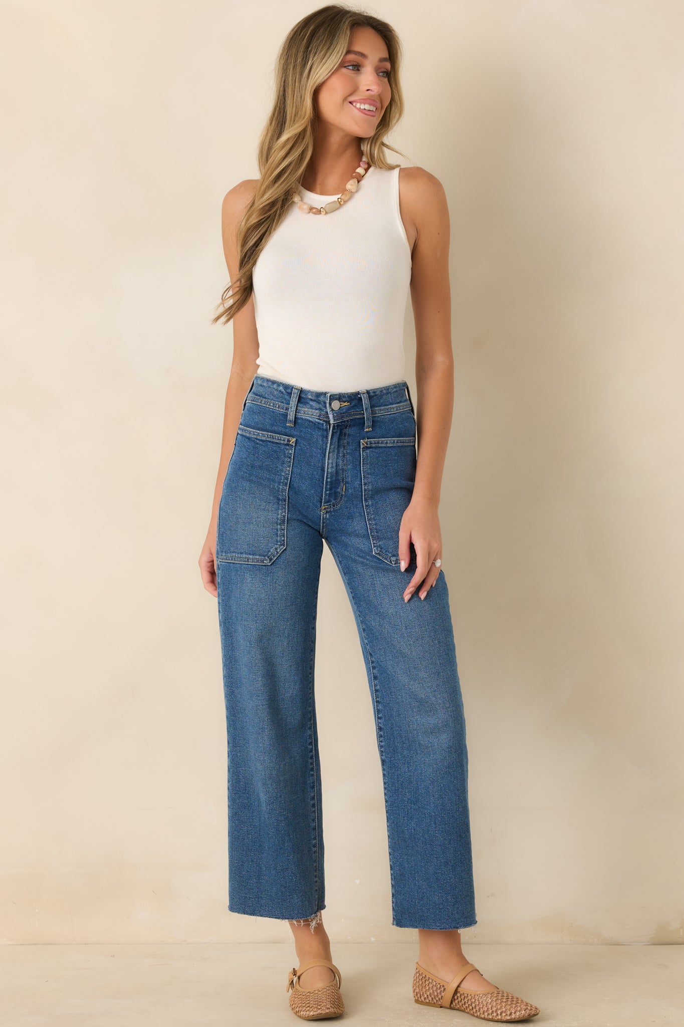 Classic ivory ribbed tank top with a fitted silhouette, rounded neckline, and soft texture.