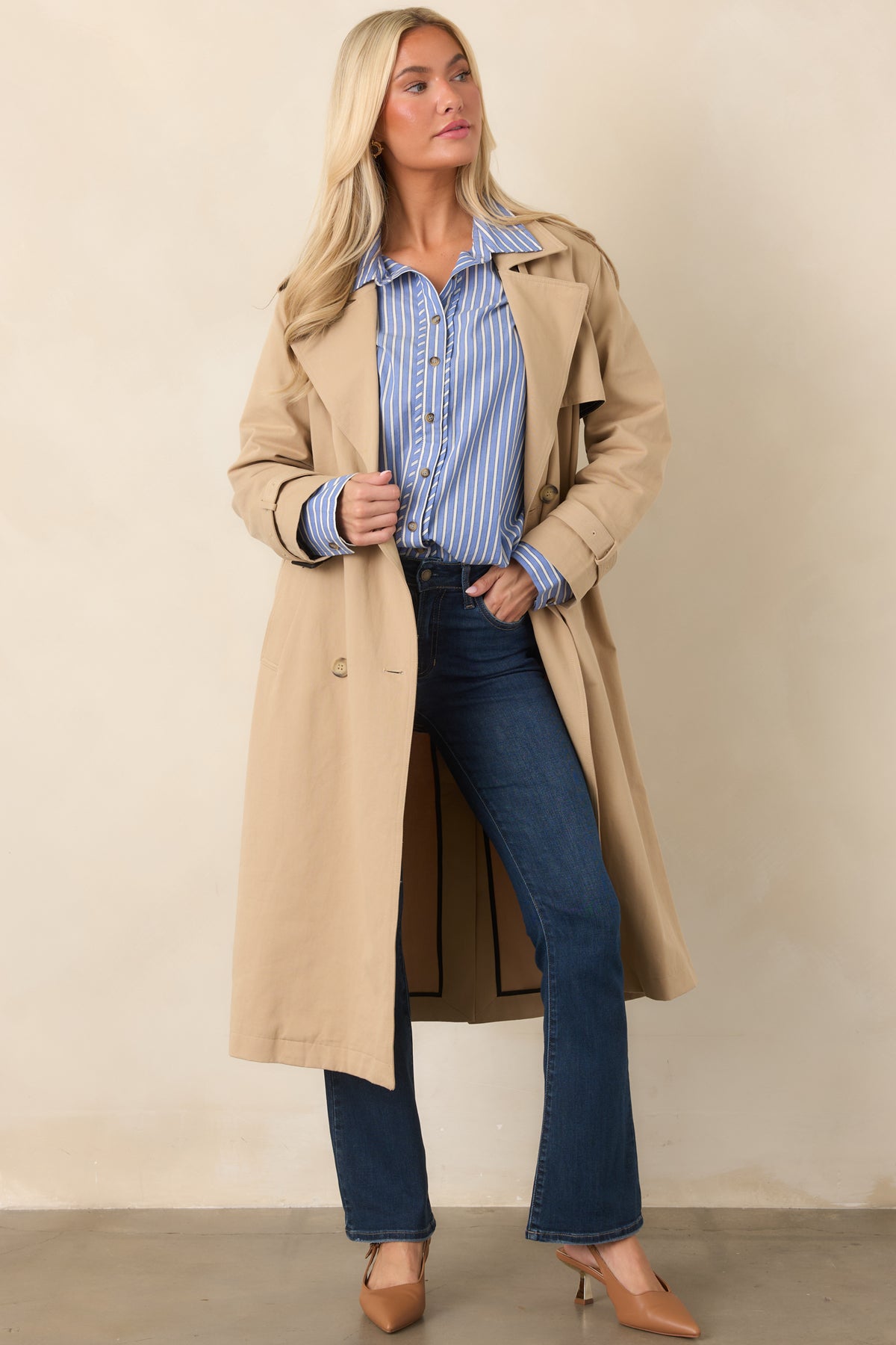 Classic tan trench featuring a removable waist tie, buttoned front, long sleeves with buckled cuffs, and practical side pockets.