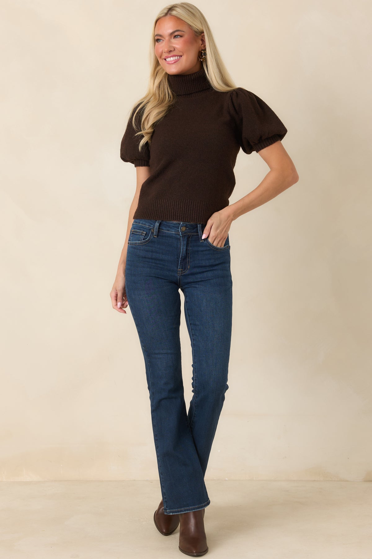Soft knit long-sleeve top featuring a classic ribbed turtleneck, elegant puff sleeve detailing, fitted cuffs, and a refined silhouette with a ribbed finish.