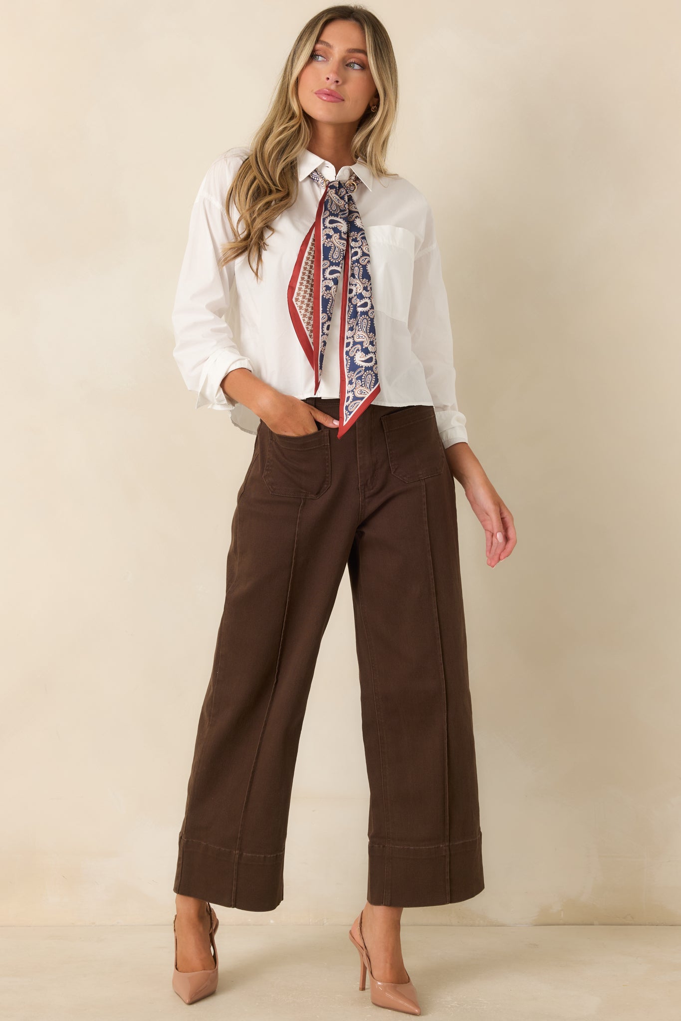 Classic white button-up top designed with a chest pocket, button cuffs, and a timeless relaxed silhouette.
