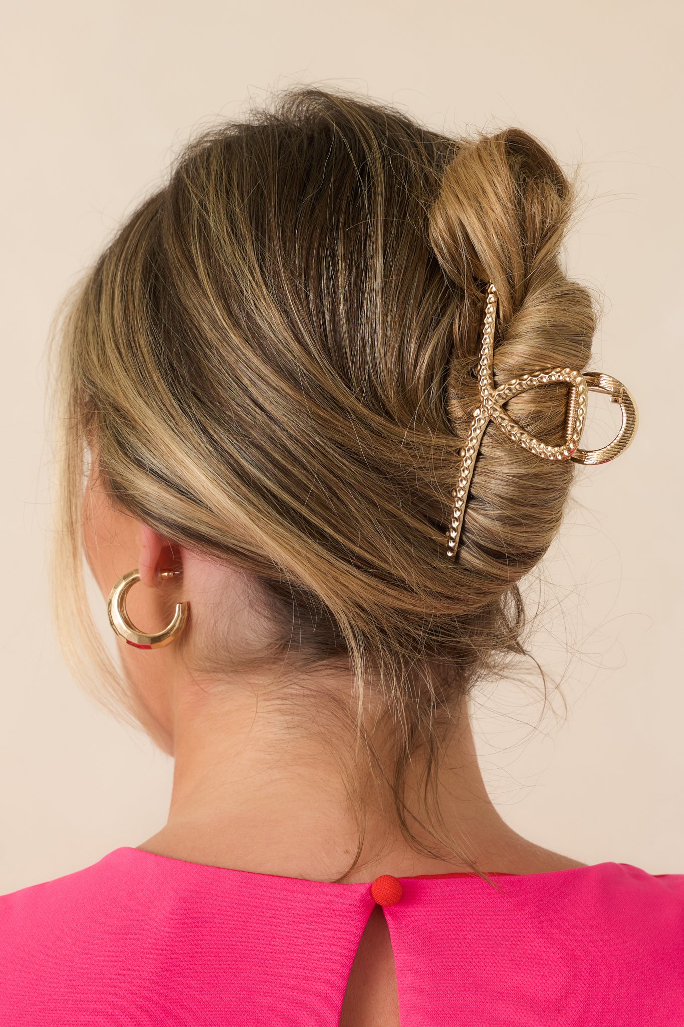 Close view of the claw hair clip highlighting the looping silhouette, textured surface, and polished styling accessory design.