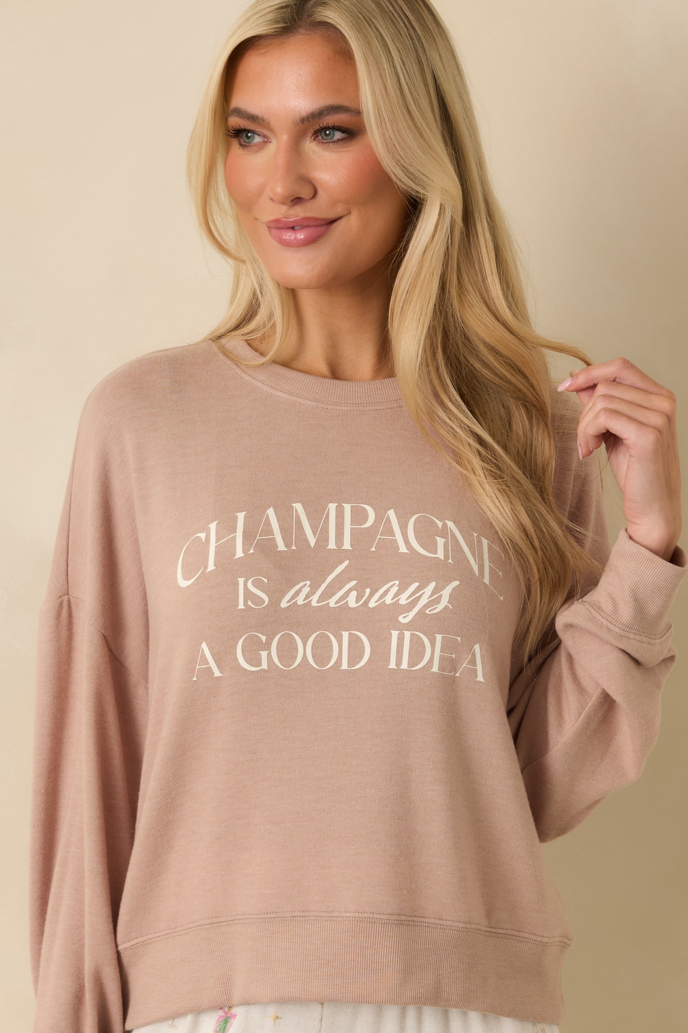 Close crop of front taupe top, highlighting crew neckline and dropped shoulder seam details.