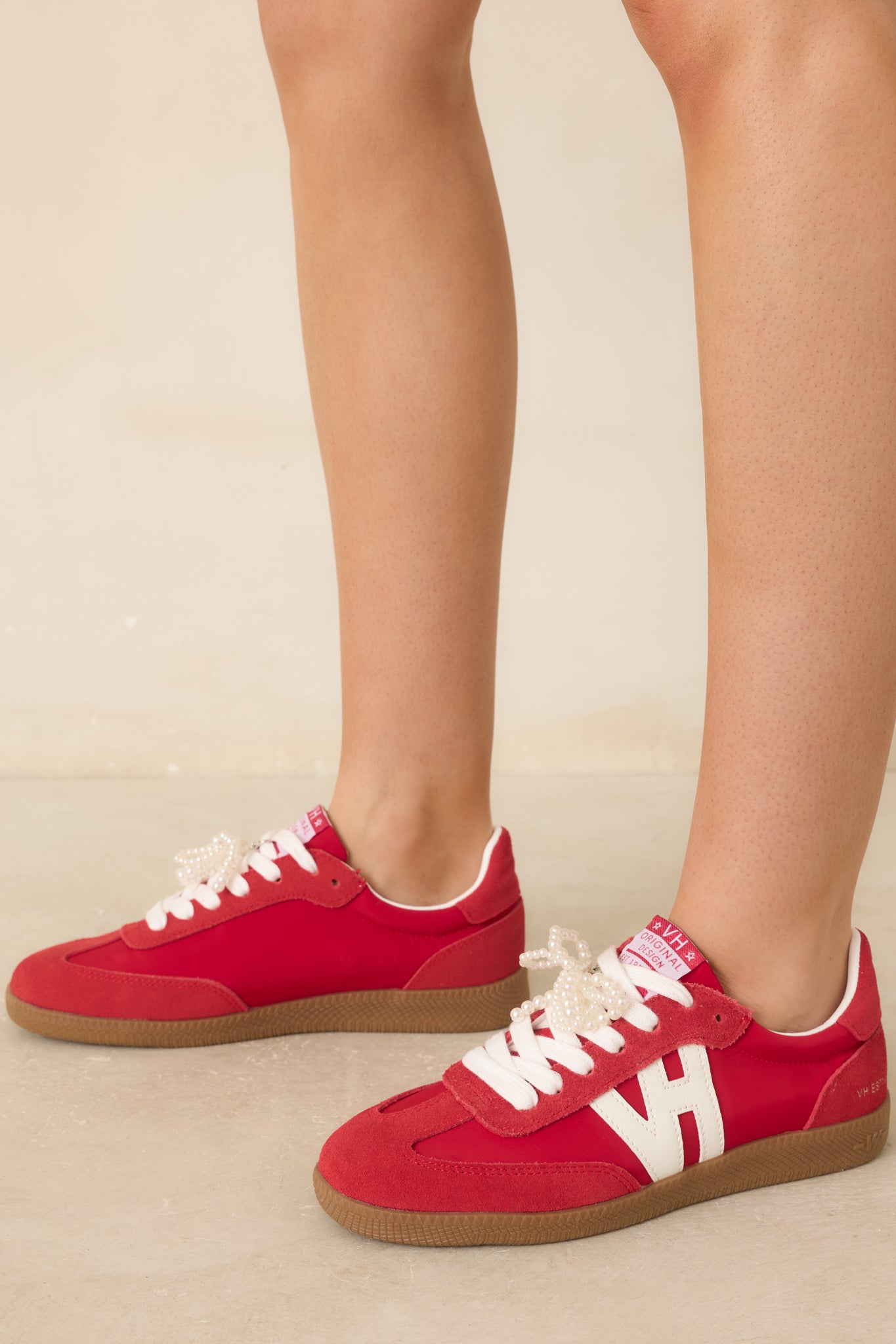 Close-in crop highlighting pearl bow accent and layered suede, leather, and synthetic materials.
