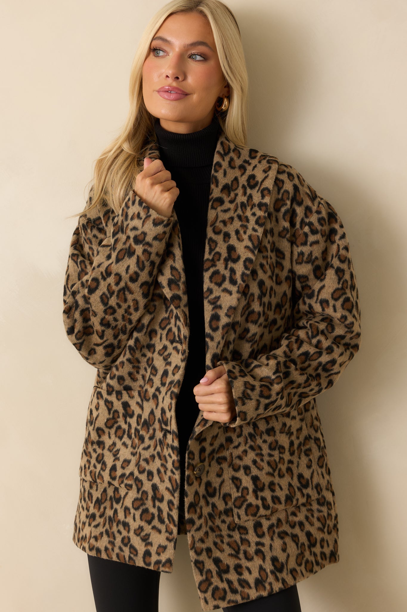 Close crop showing notched collar and single-button closure on tan leopard print coat.