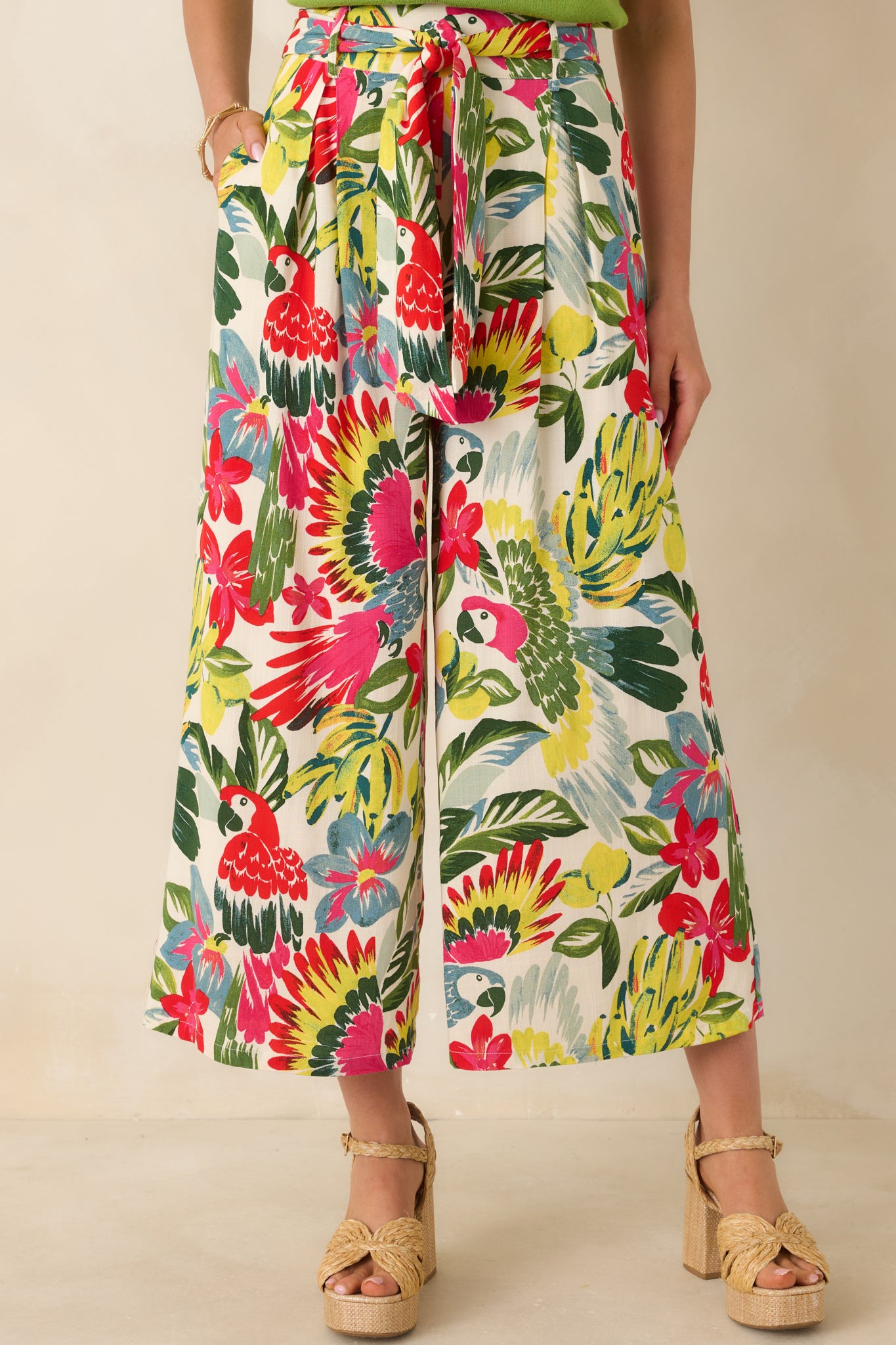 Close cropped angle of high-rise pants showing bold floral print, wide-leg silhouette, and breathable fabric