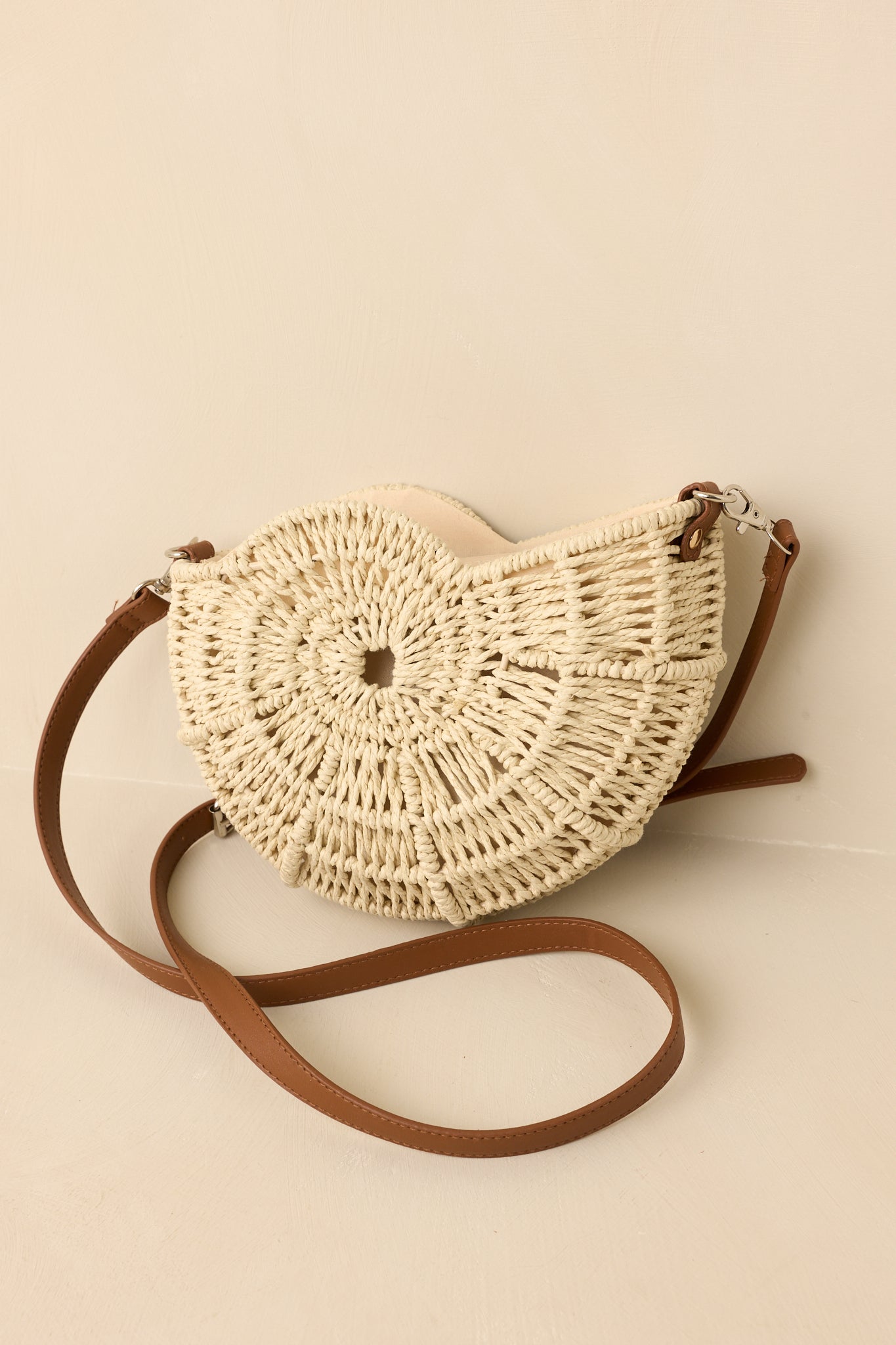 Close cropped angle of crossbody bag showing structured nautilus-inspired shape and polished hardware