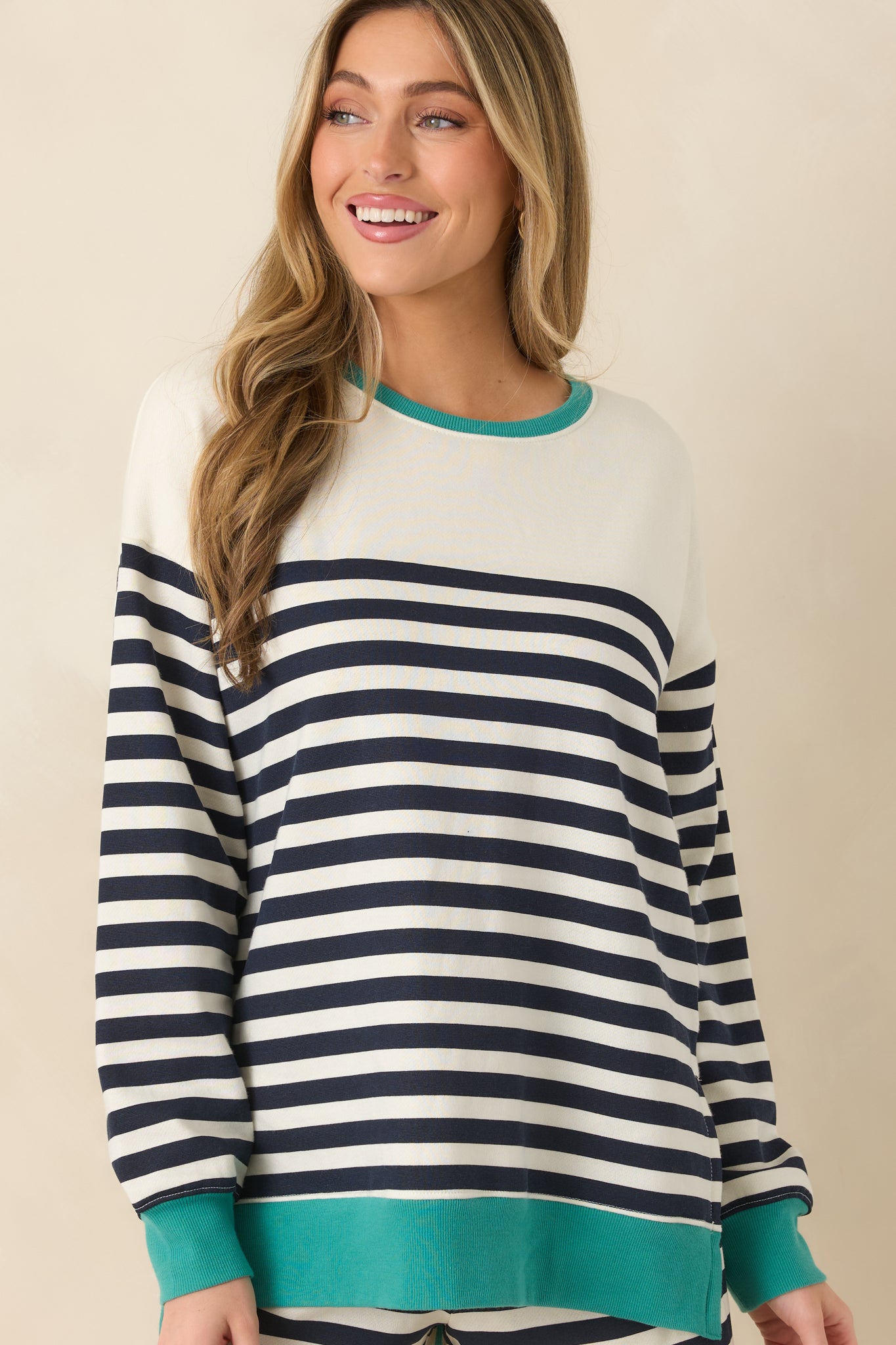 Close cropped image showing horizontal stripe pattern and contrasting ribbed cuffs in a green hue.