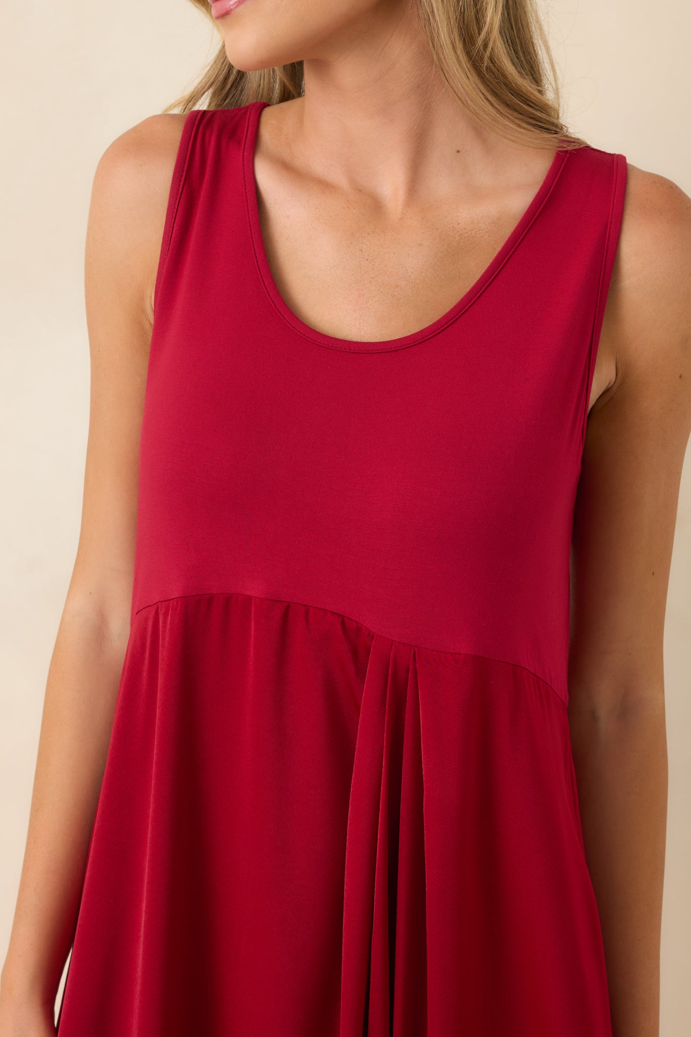 Close detail of the stretch-knit top designed with a flattering scoop neckline and a sleeveless design.