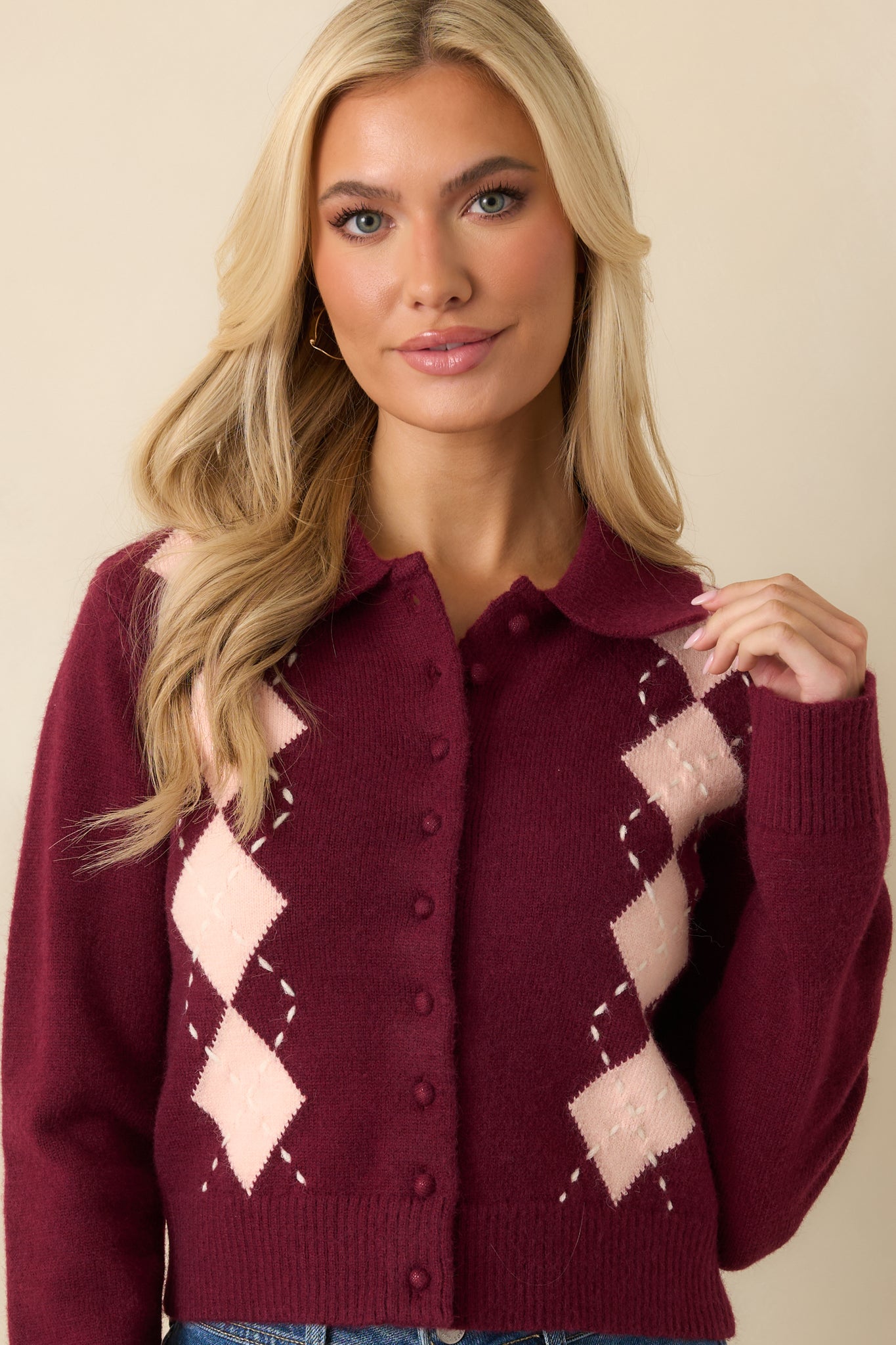 Close-front crop focusing on knit texture, ribbed hem, and patterned stitching across cardigan.