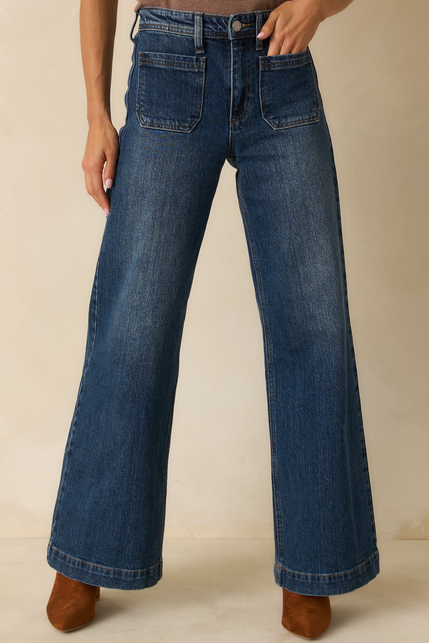 Close front view highlighting the high-rise waistband and button-zip closure of the jeans.