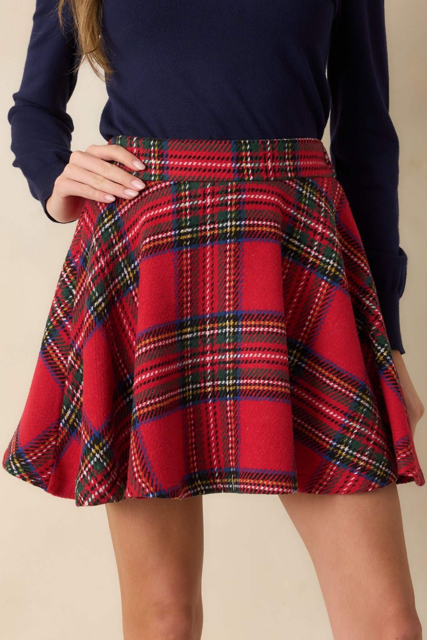 Close-in front crop emphasizing plaid pattern, structured waistband, and flared shape.