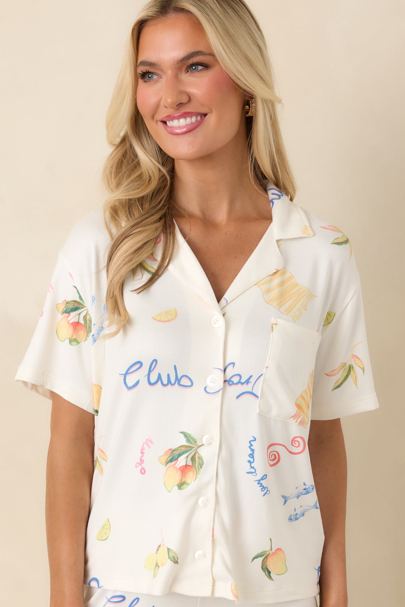 Close cropped look at vanilla-toned pajama shirt showing collar and whimsical beach-themed pattern