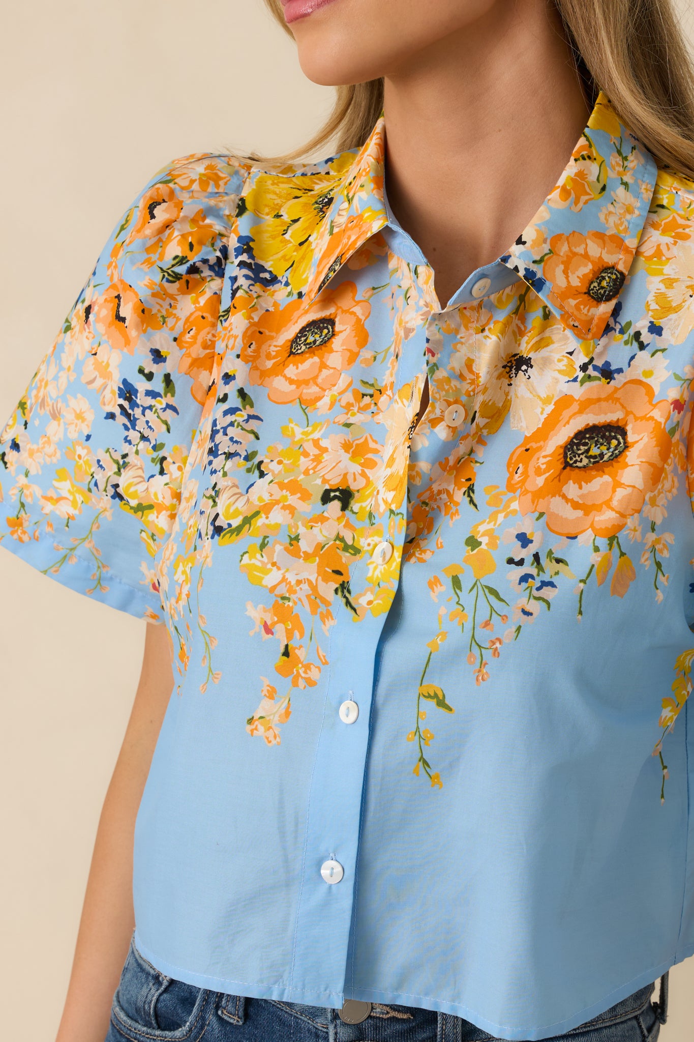 Close-up of the multicolor floral print on the blue cotton fabric with visible button-down detailing.