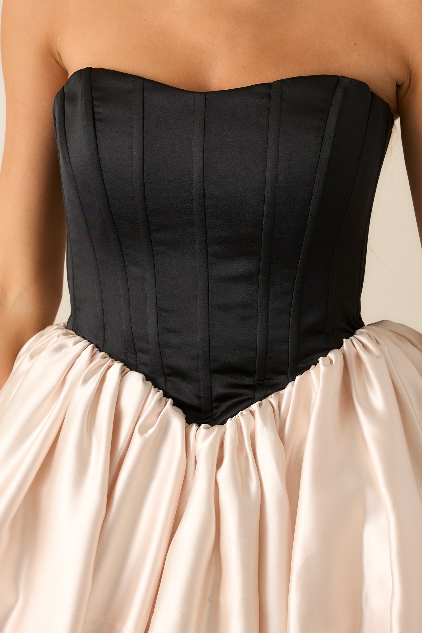 A close-up of the black strapless corset top, showcasing the structured boning and sculpted fit.