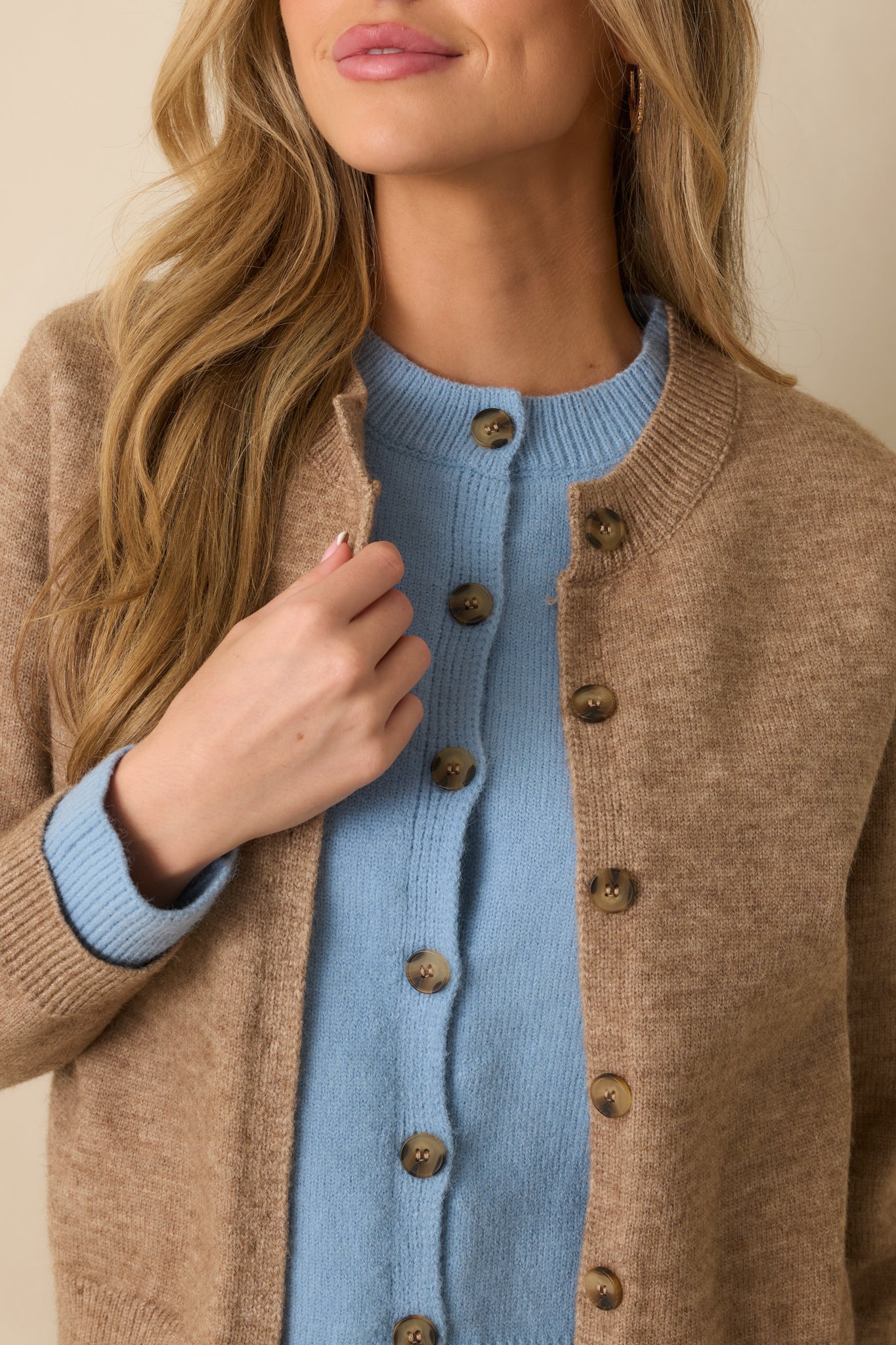Zoomed-in view of the button front closure and layered effect showing the contrast between the mocha knit and light blue inner layer.