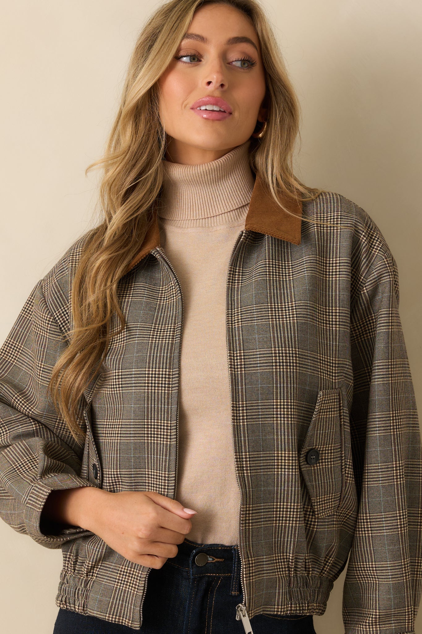 Close-up of the corduroy contrast collar and front zip closure on the brown plaid bomber jacket.