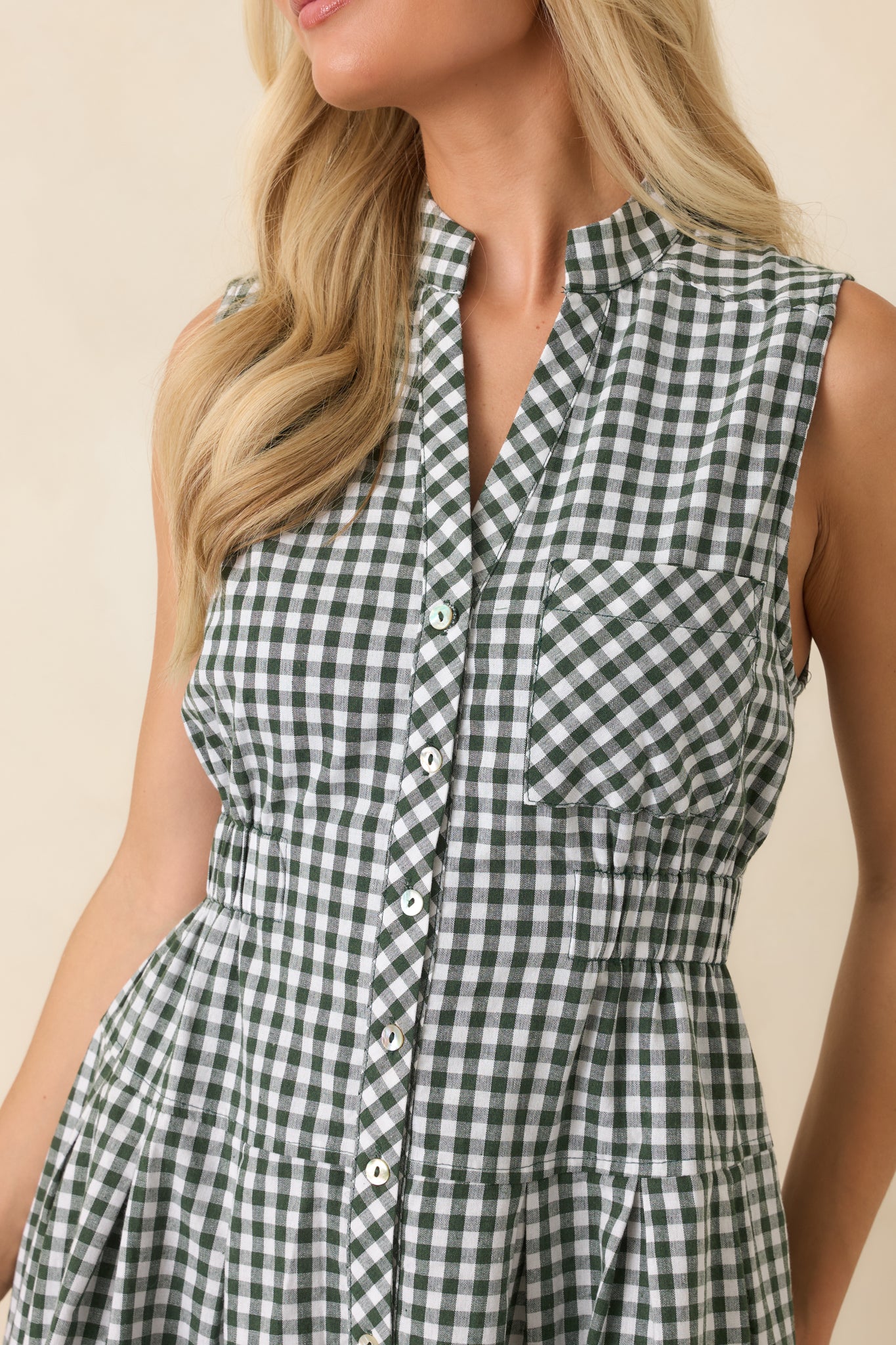 Close-up of the gingham mini dress highlighting the collared neckline, button-front placket, chest pocket, and fabric pattern.