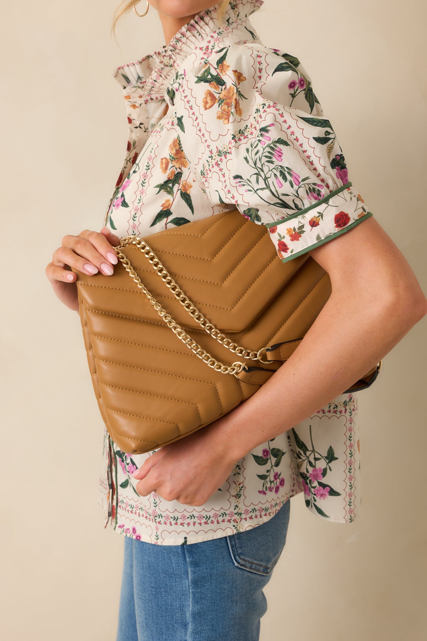 A closer shot of the bag emphasizing its elegant gold chain and rich tan color. 