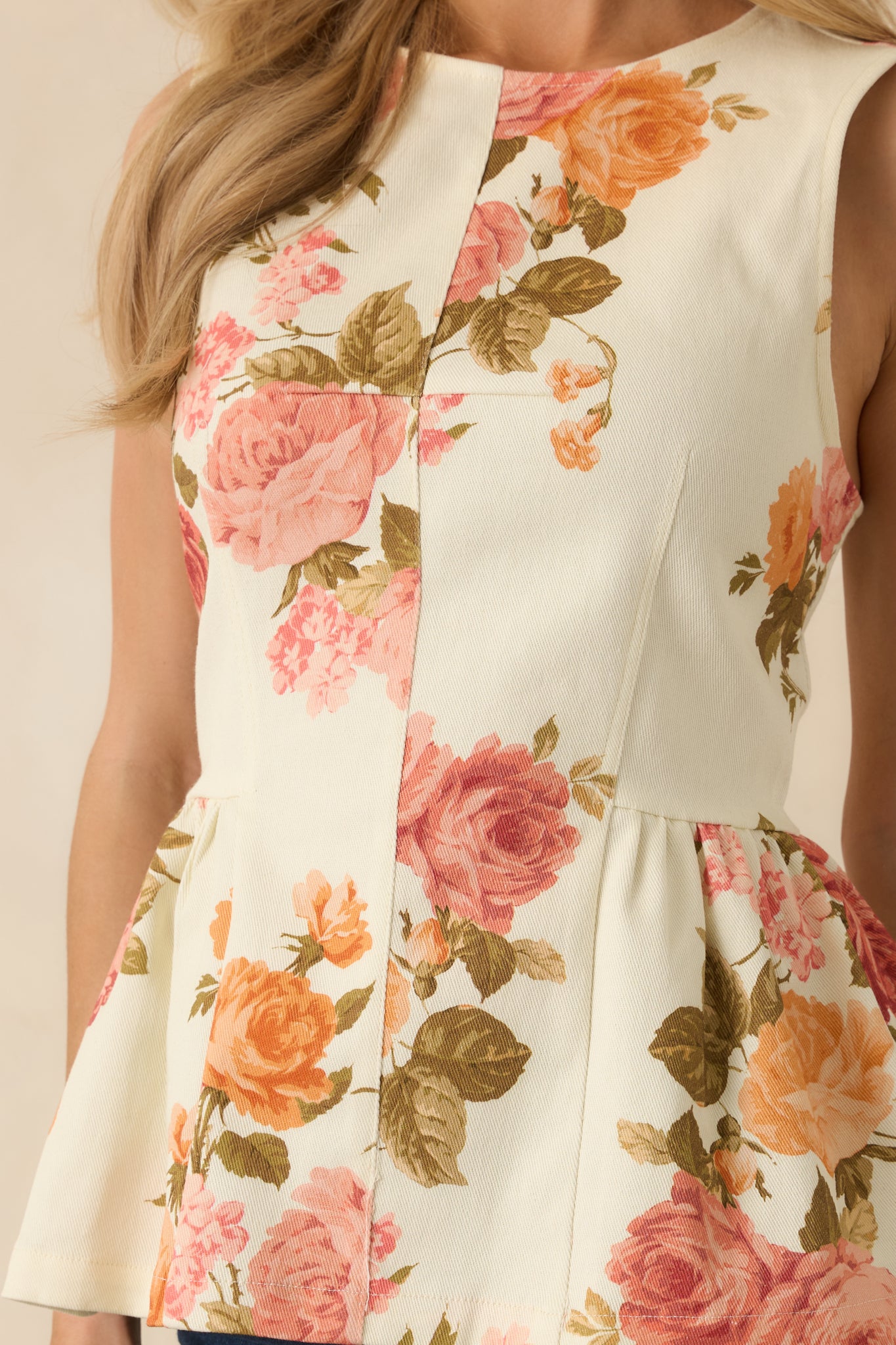 Close-up highlighting the pink floral print, structured bodice, and delicate stitching along the peplum hem.