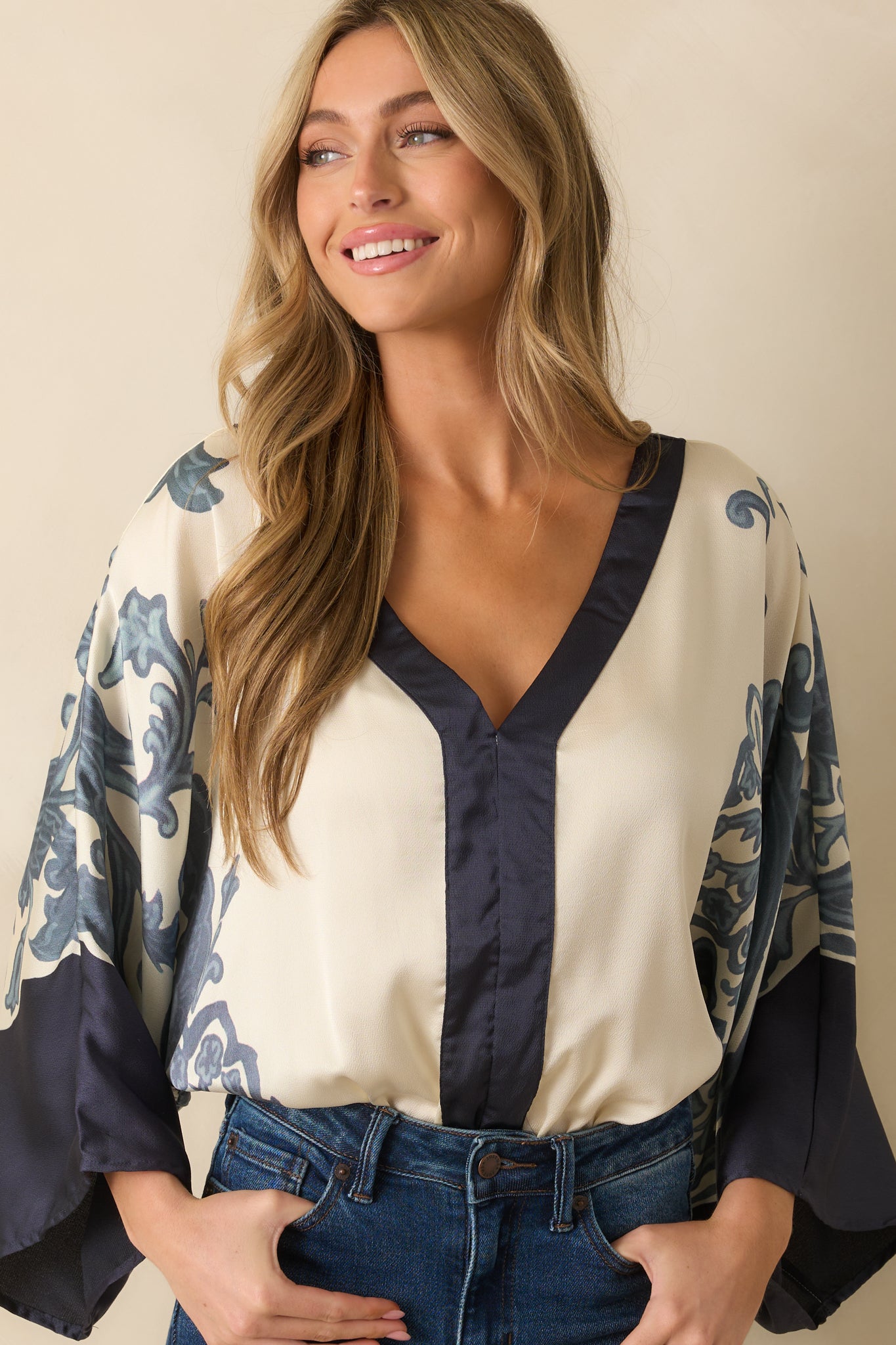 Midsection close-up highlighting the bodysuit’s ivory base and ornate navy pattern.