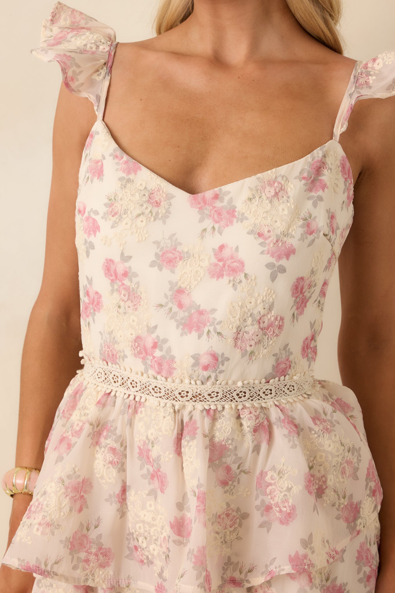 Close-up of the waist area highlighting the open ladder-lace detail and embroidered floral accents.