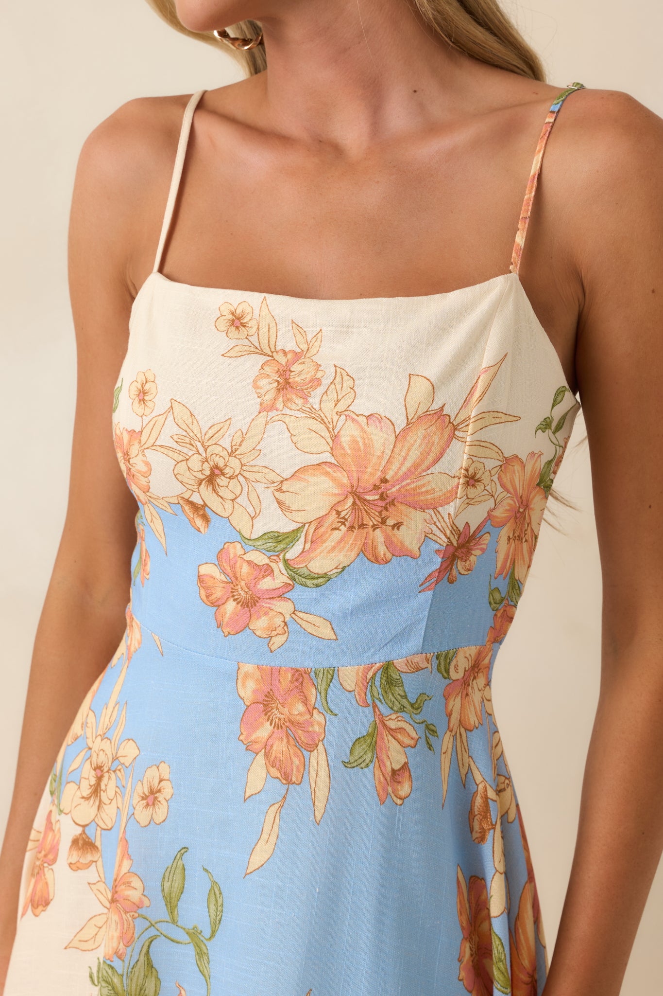 Close-up of the blue and ivory fabric highlighting the peach and blush floral blooms, square neckline edge, and color-block detailing.