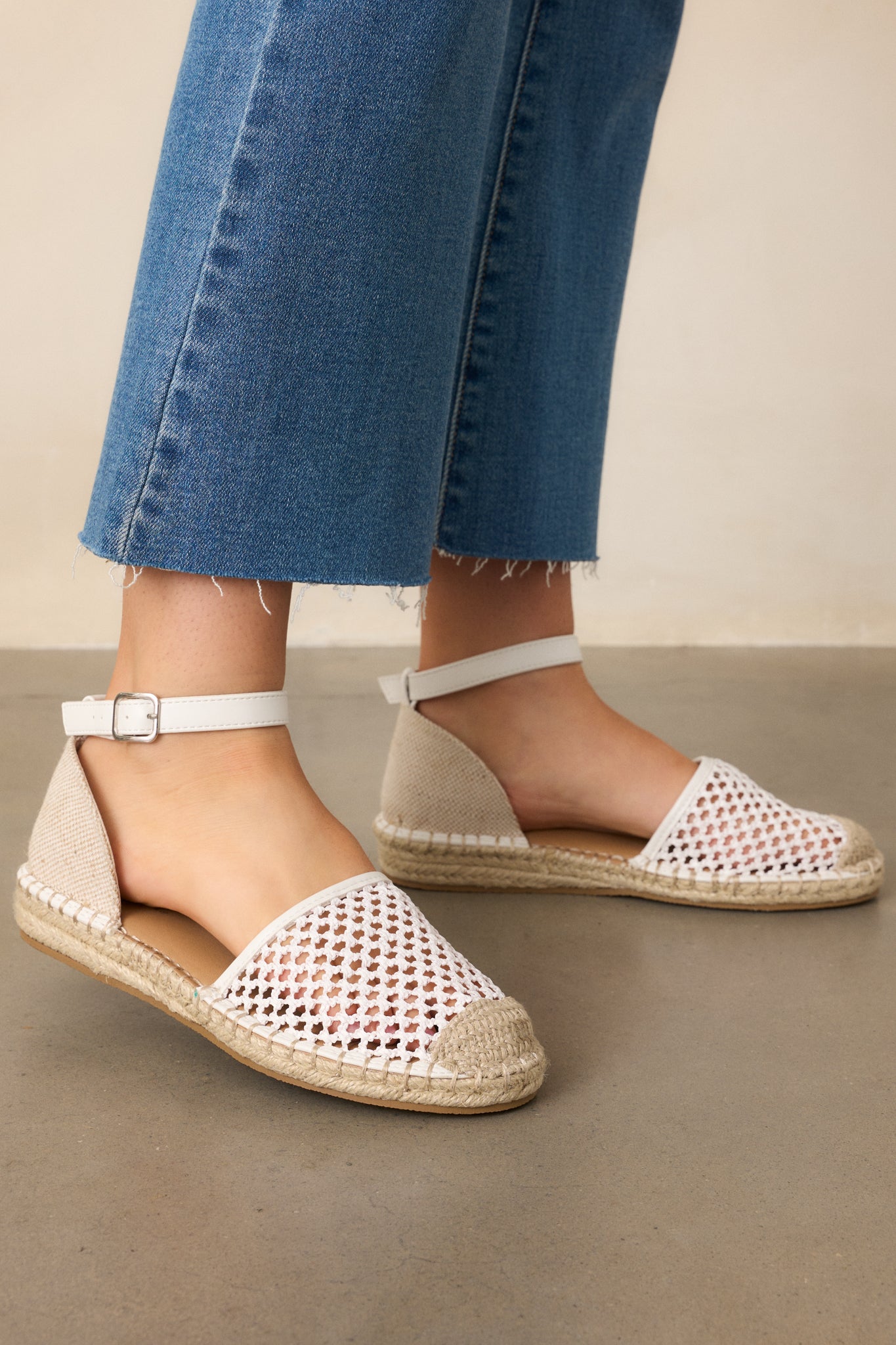 A close-up of the ivory flats, showcasing the breathable closed-toe design with open woven fabric.